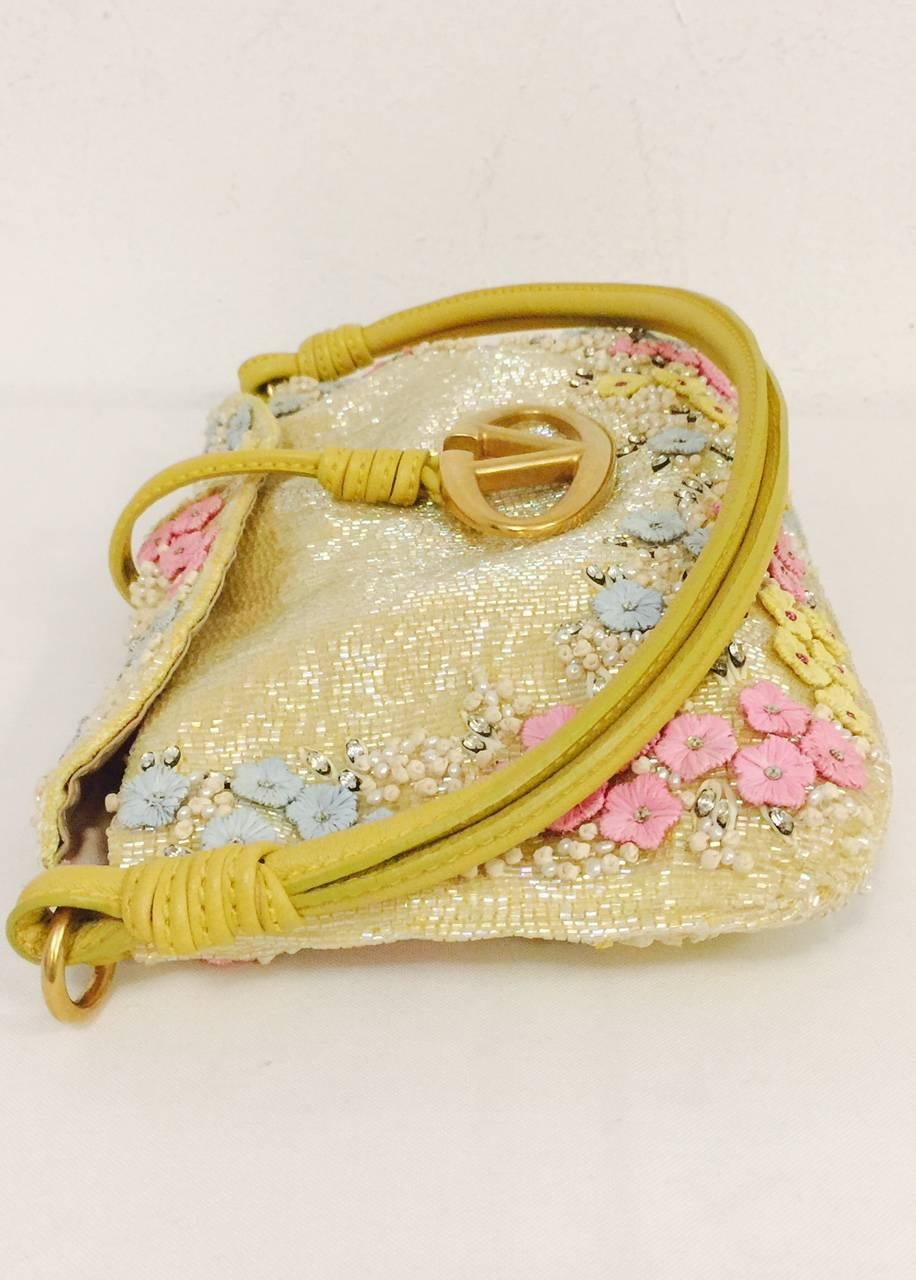 Valentino Garavani has always been known for his unabashed feminine designs!  This Beaded and Embroidered Satin Flap Evening Bag is no exception.  Features exquisite pale yellow satin exterior with beading allover.  Delicate pale blue, pink and