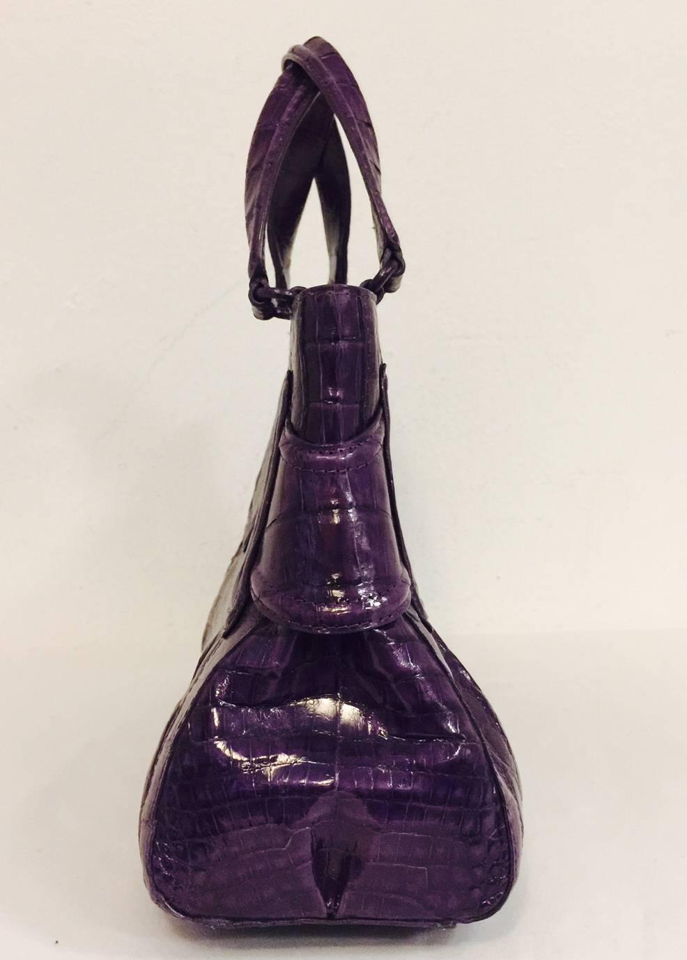 Nancy Gonzalez Aubergine Crocodile Structured Hand Bag is a must for all devotees of her designs! Crafted in Colombia, bag features ultra-luxurious crocodile in a regal shade of purple. Double flat straps are attached to bag with crocodile covered