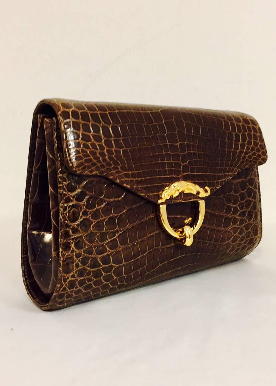 Kwanpen Deep Cognac Structured Bag is heirloom worthy!  Features ultra-luxurious crocodile exterior, gold tone hardware, and chocolate leather lining.  Gusseted sides.  Interior zippered pocket and 2 open accessories pockets maintain order.  Flip