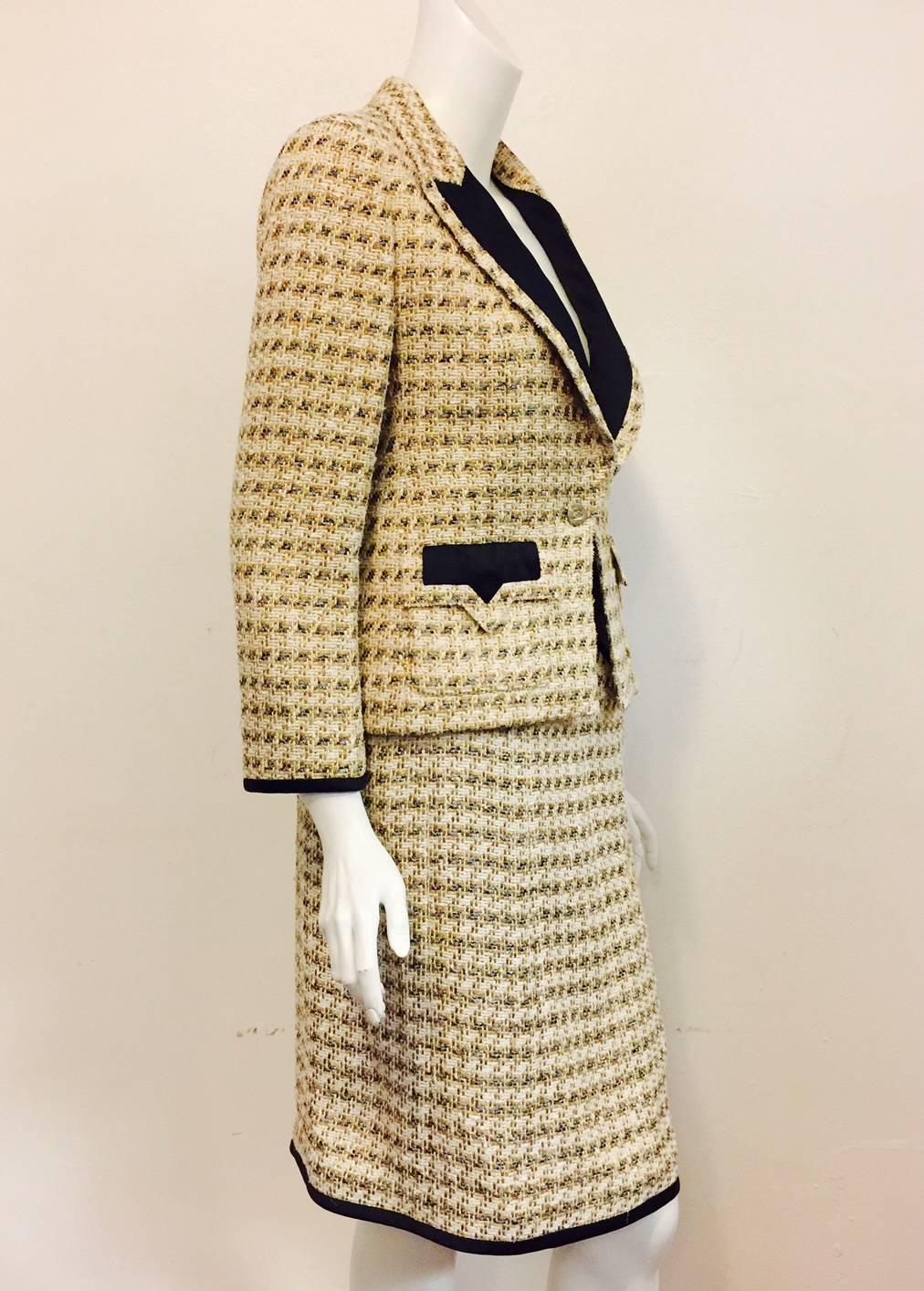 Crafted in 2006, this Chanel Metallic Tweed Skirt Suit effortlessly glides from day to evening!  Features signature fabric infused with platinum, gold, and silver metallic threads.  Peaked lapels and flap pockets are trimmed in black silk satin.
