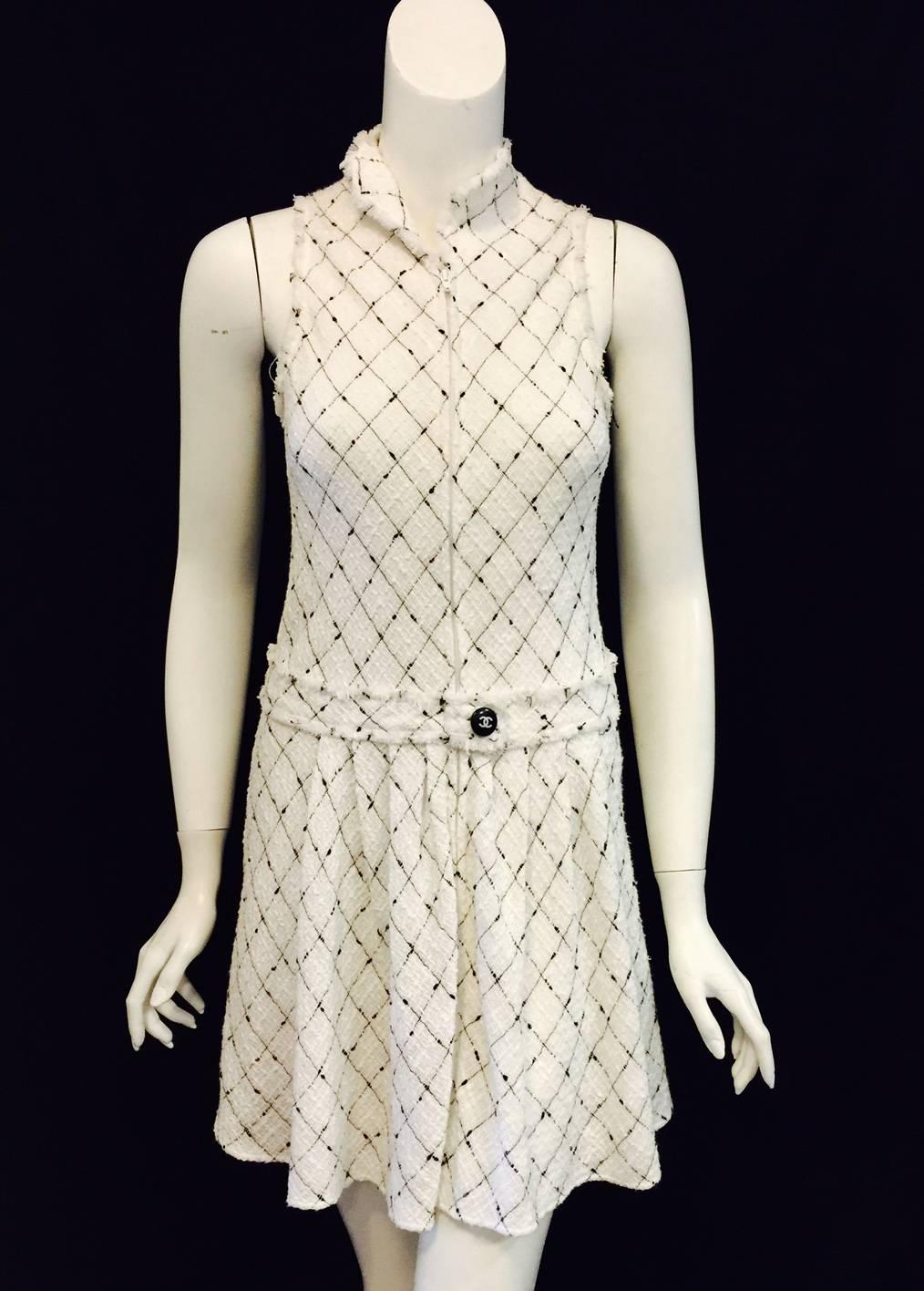 Chanel Spring White Cotton Dress pays homage to the design sensibilities of Coco herself!  Features signature tweed fabric, sleeveless design and high collar.   Zippered front closure.  Banded dropped waist with iconic black and white logo button,