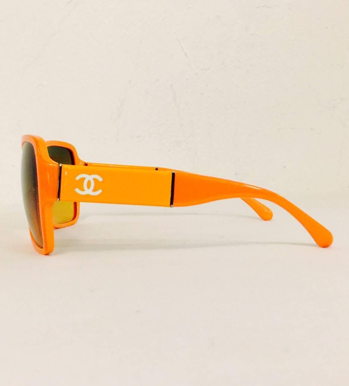 Make an unforgettable statement when wearing these orange Chanel sunglasses.  Features dramatic and rounded amber tinted lenses and white double 