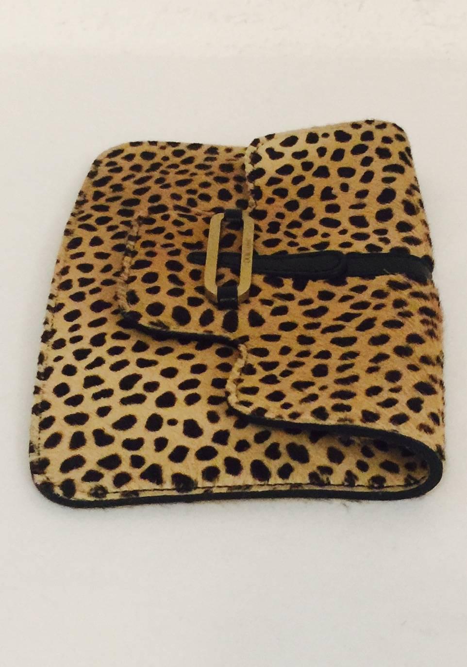 Leopard Print Pochette proves that Jimmy Choo is so much more than just shoes!  Features exquisite calf hair, gold tone hardware bearing signature logo and flap with snap closure.  Leather and nylon interior houses one zippered comparment under