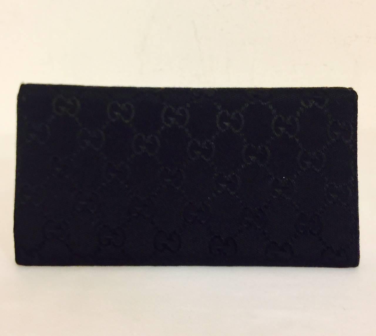 Gucci Black Tri-Fold Long Wallet is a necessary accessory for any sophisticated lady!  Crafted from ultra-luxurious signature canvas, wallet features black smooth leather lining, iconic silver tone plate on snap closure, and several compartment for