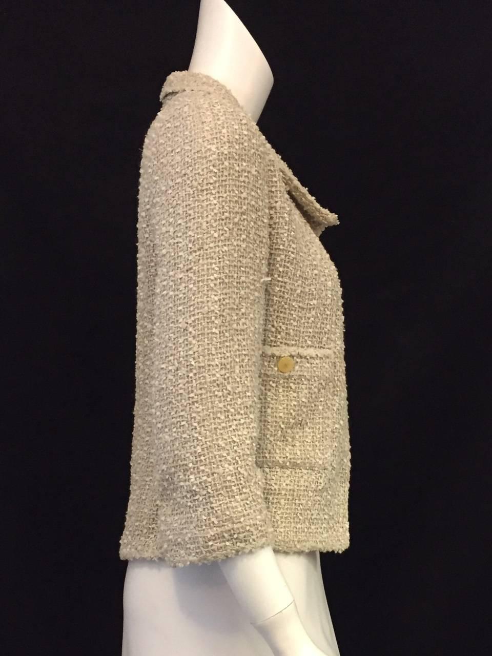Chanel Beige Tweed Jacket is classic "Coco"!  Features the iconic tweed fabric that made Mademoiselle a household name, bracelet sleeves and two buttoned patch pockets.  No closure.  Ageless and timeless design works equally well with more
