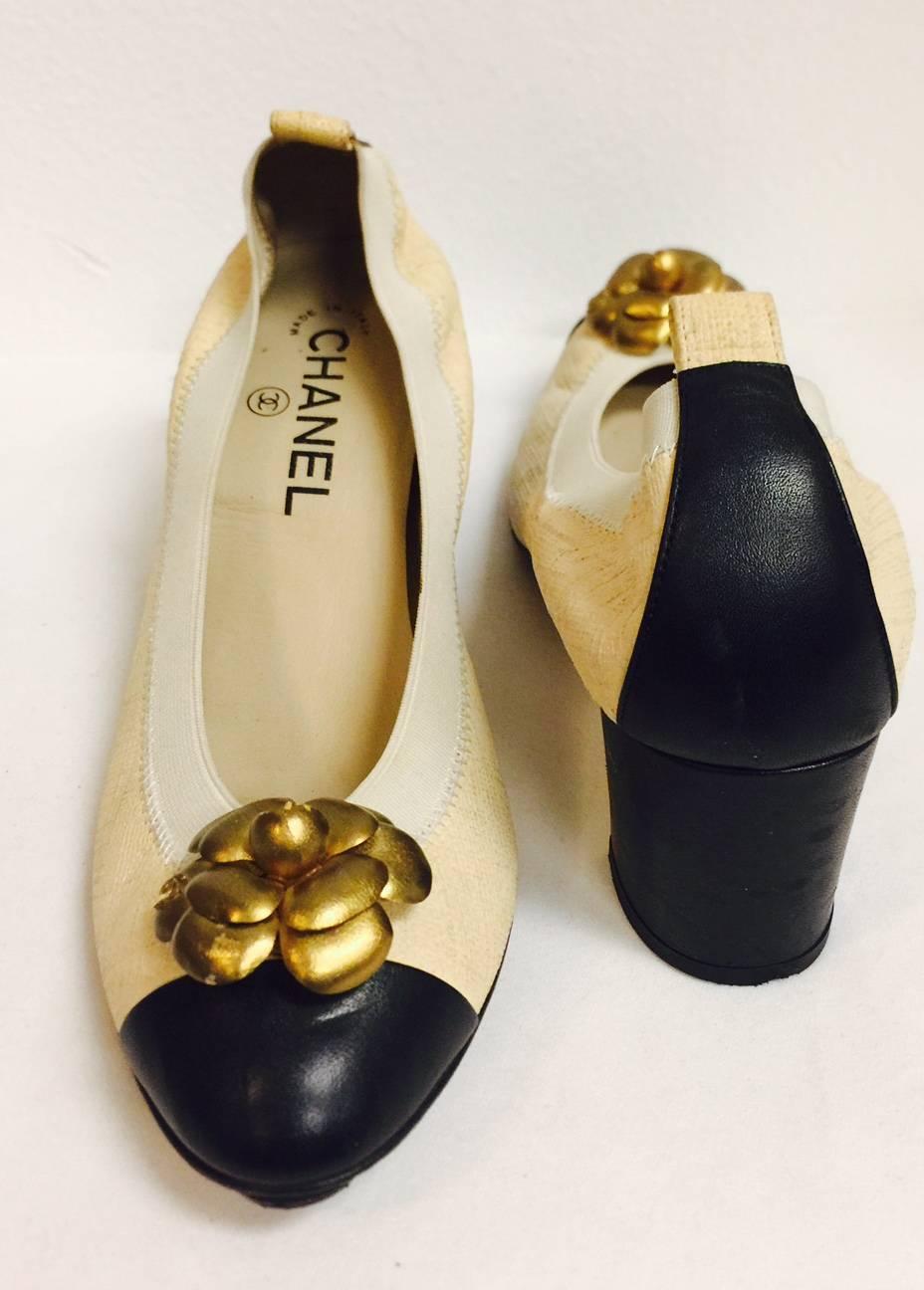 Ageless and Seasonless Chanel Black and Tan Pumps are as iconic as Mademoiselle herself!  Features textured tan leather and smooth black leather heels and cap toes.  Durable elastic band guarantees a comfortable fit!  Leather insoles and lining