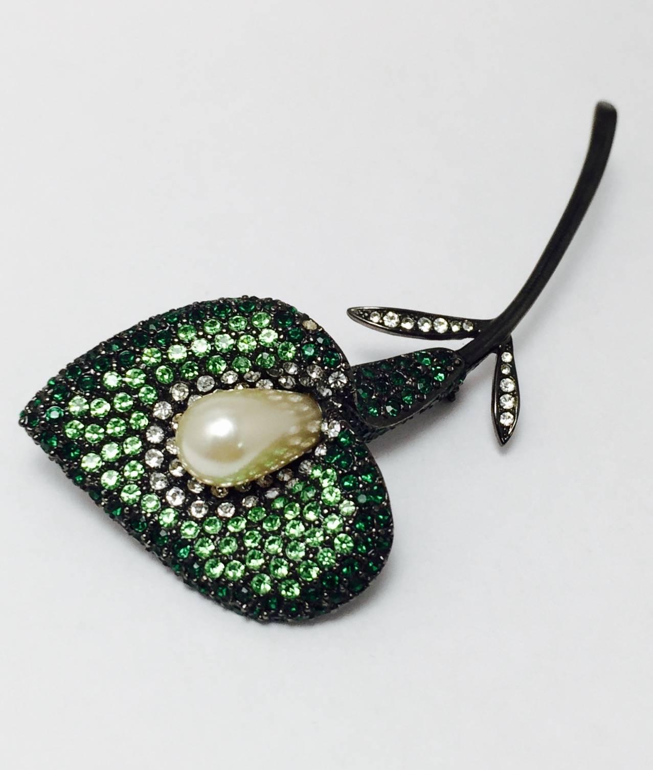 Kenneth Jay Lane has become wildly collectible!  This outstanding Calla Lily brooch will enhance whatever you're wearing!  Blackened metal serves as the perfect back drop for Swarovski crystals in clear, light green and dark green.  The center, or