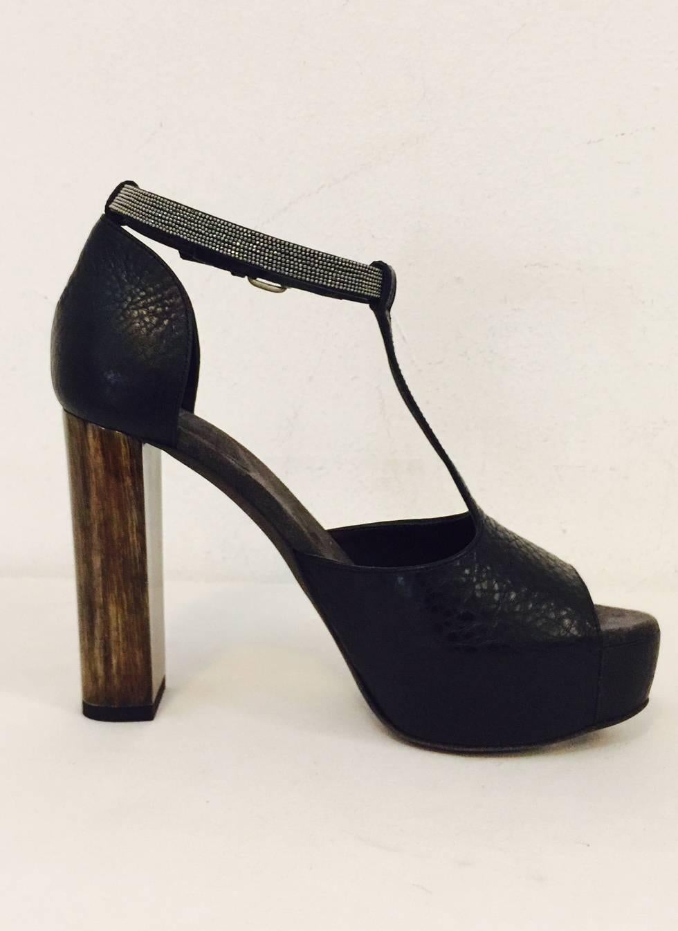 Black leather Brunello Cucinelli platform pumps with peep-toes. Monili covered ankle straps and buckle closure at side.  These platform sandals are very comfortable and with the Monili chain accent on the ankle strap, makes it oh so glamorous. 
