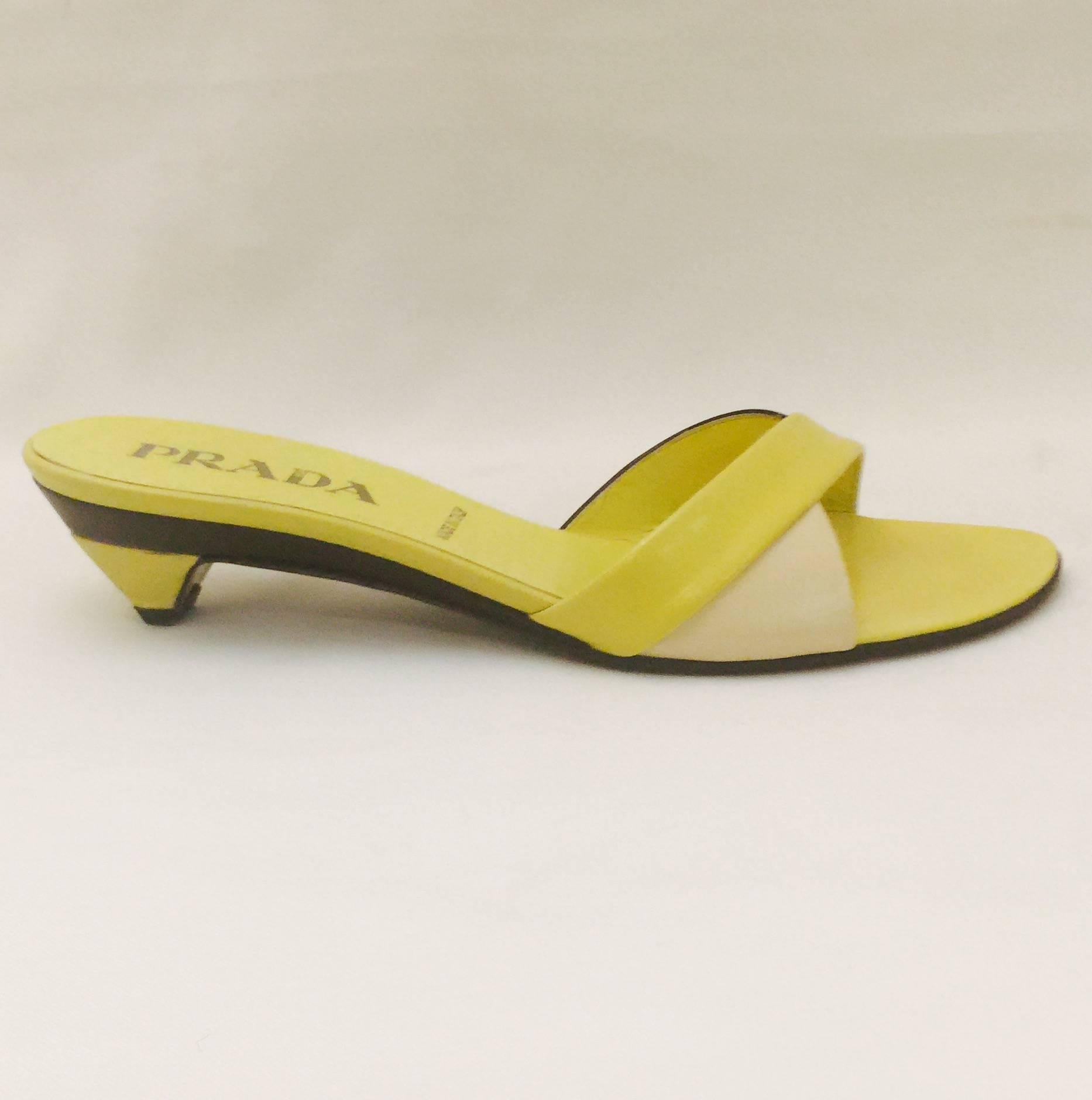 Prada Chartreuse Yellow Color Blocked Slide Sandals are classically feminine and a must for all devotees of Miu Miu!  Features exuberant black, ivory, and chartreuse yellow color blocking on architectural heels and across the strap vamps.  Leather