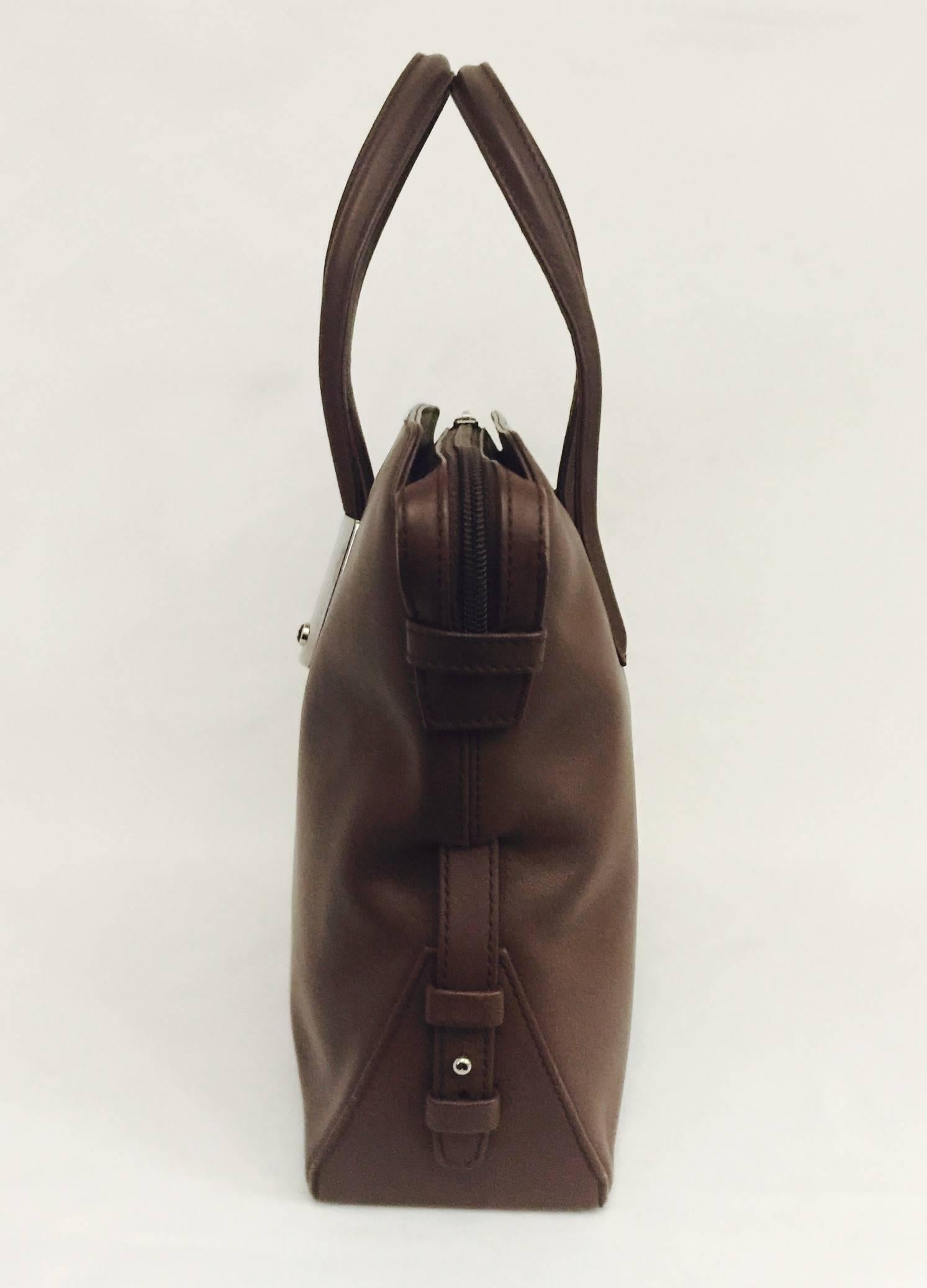 Montblanc craftsmanship resonates in this handsome handbag!  Features include 2 top flat handles and the Montblanc star logo on one of the handles in front of bag.  Zippered closure on top of bag offers security and reveals beige suede interior with