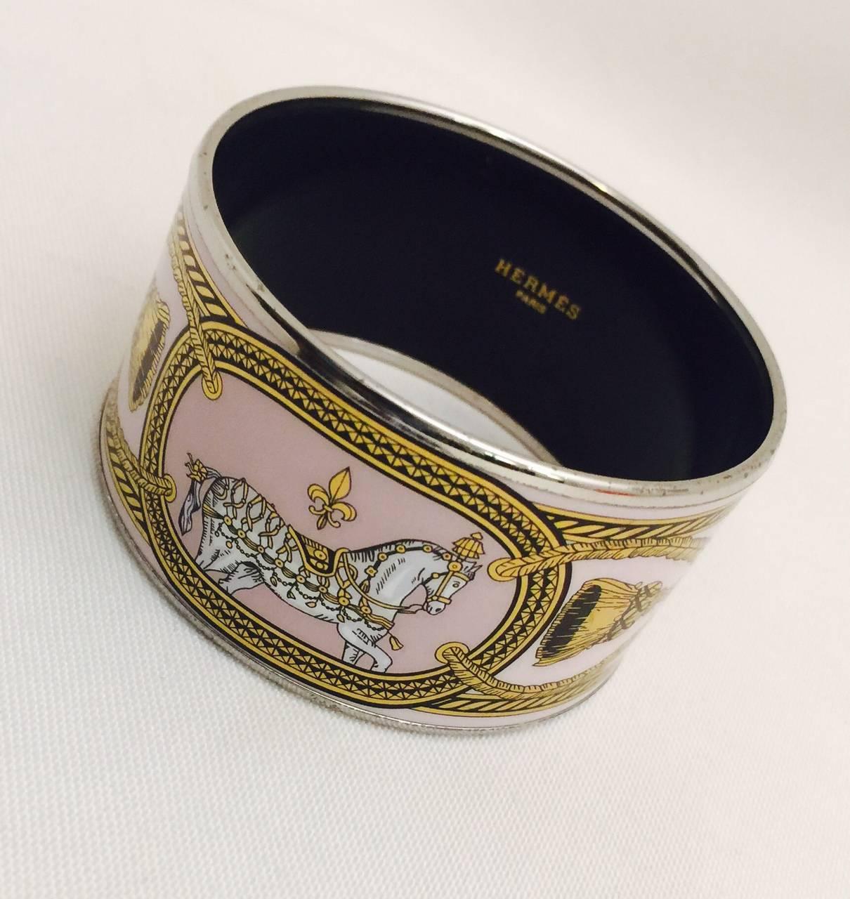 Hermes enamel cuffs are recognizable at a glance.  Always stunning.  Always in style.  A wear it daily piece!  This Grand Apparet cuff features stand out pink enamel, a dress parade horse, 'rope' detail ending in tassels.  Medium size.
Properly