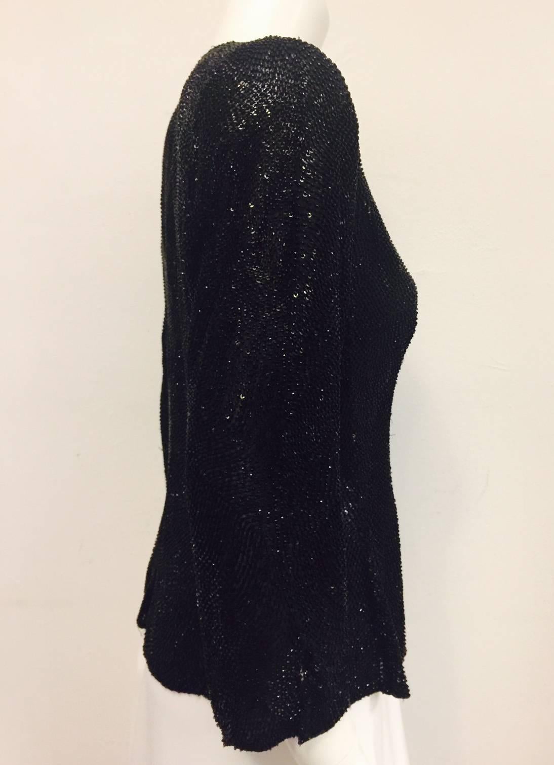 Glamorous Giorgio Armani silk evening jacket is encrusted with black sequins and beads allover.  Signature collar and slit bracelet sleeves.  Fully lined with slightly padded shoulders. Two hidden buttons finish the look.  Wear with everything from