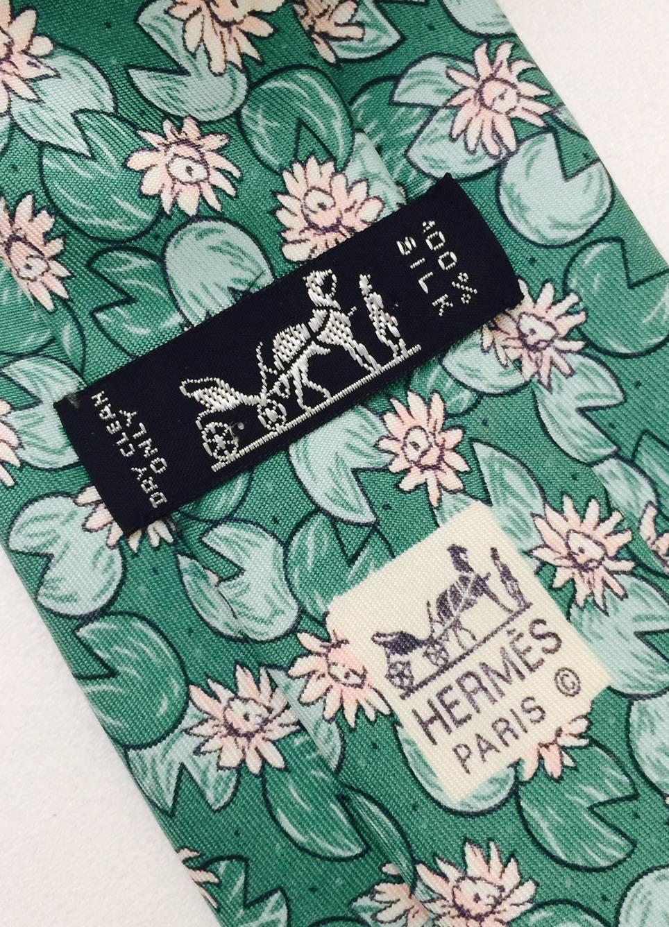Hermes silk necktie with pretty stylized water lillies in pale pink and greens. Width is 3.5 inches.