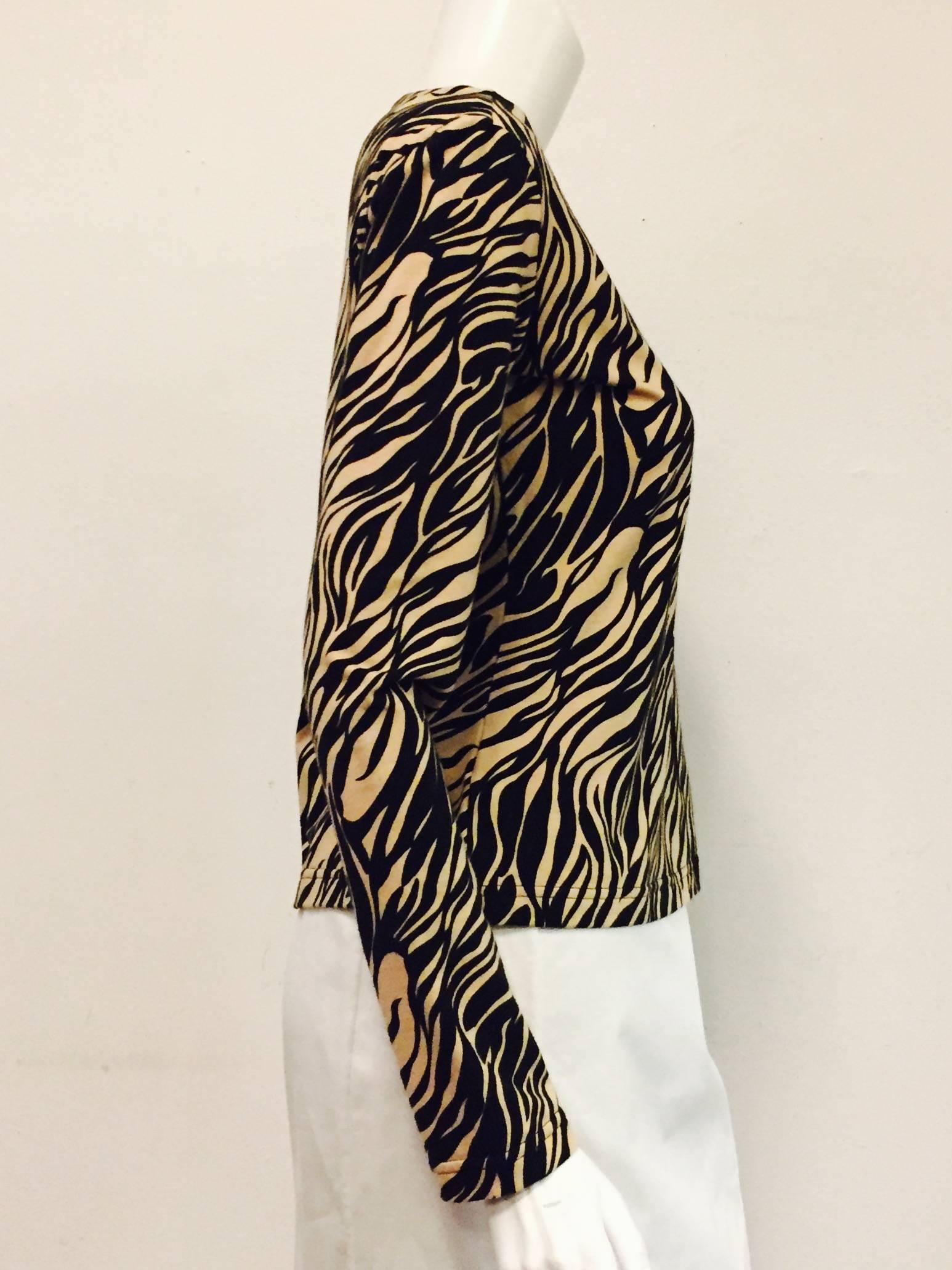 Featuring boat neckline and long sleeves, this Versace tiger print top is worthy of any vamp.  Ultra-luxurious soft cotton knit is versatile enough to be worn with a casual pair of slacks or beneath a smart jacket.  Excellent Condition!  Made in