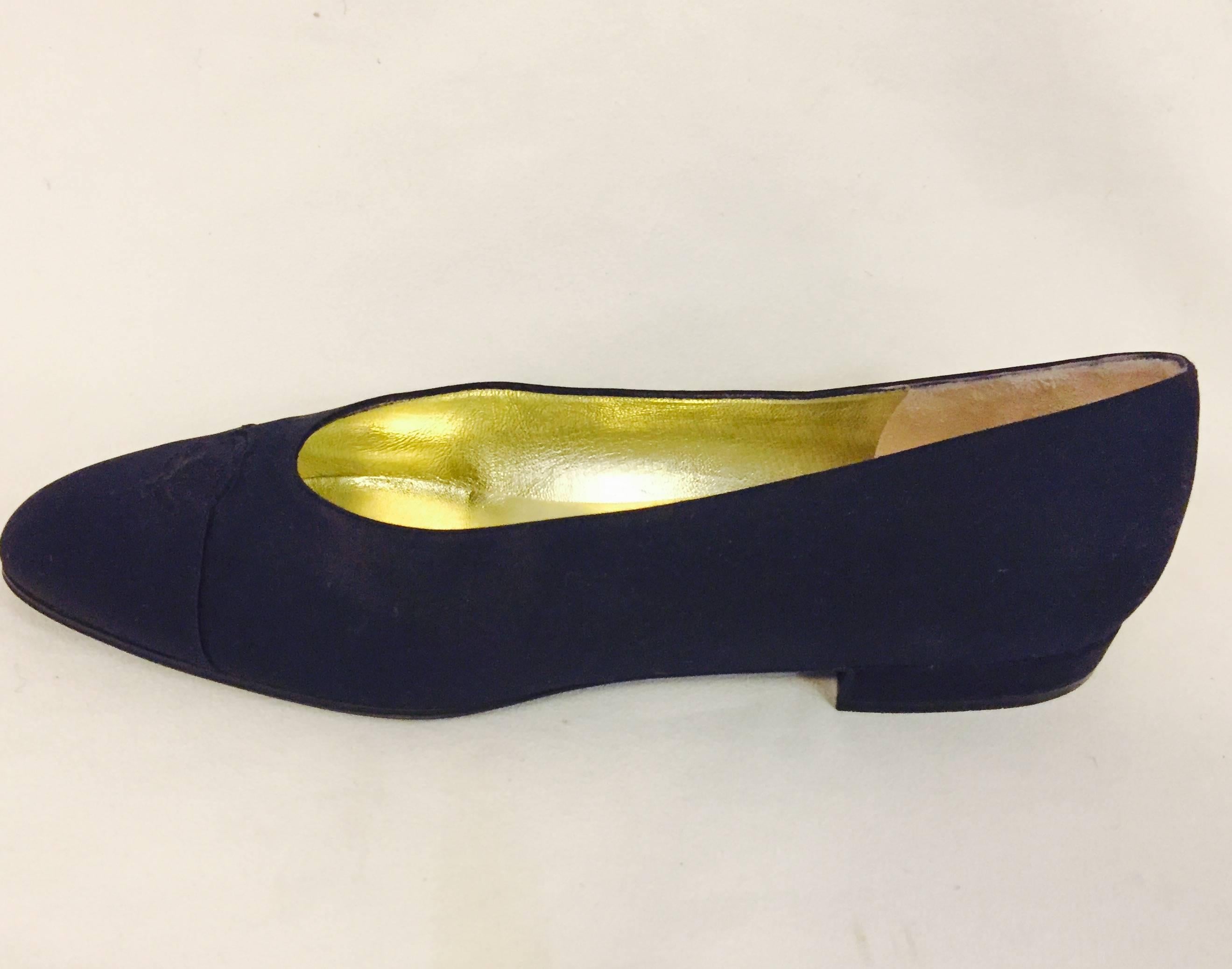 These classic Chanel black satin cap toe flats fully lined in gold tone leather are spectacular.  The CC logo stitched in same satin material at top of shoe a must for dressing up a work ensemble.  In excellent condition!!  Made in Italy
