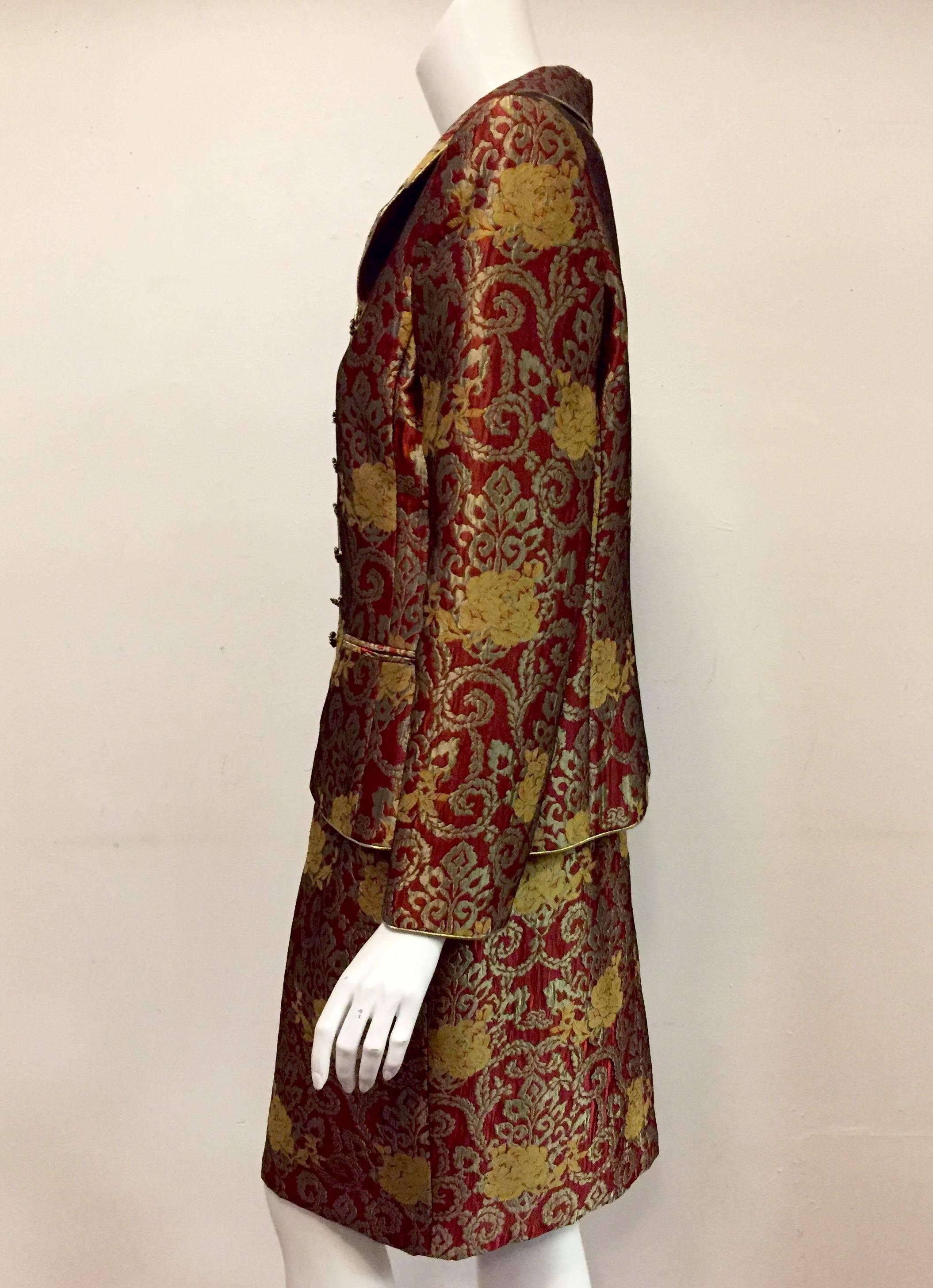 Mary McFadden's magnificent rust, bronze and gold brocade suit features 8 rust color rhinestone buttons on jacket front.  Jacket features notched collar with gold cord trim on collar, front closure, cuffs and hem.  `Two faux pockets at front finish