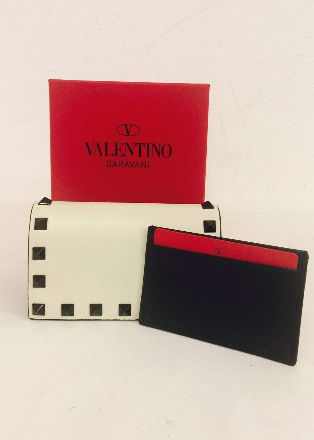 Valentino Vitello Leather Wallet is quintessentially chic!  Features ultra-luxurious vitello leather, undeniably arresting black and white color-blocked silhouette and signature black rock-stud detail.  Front flap with snap closure reveals black