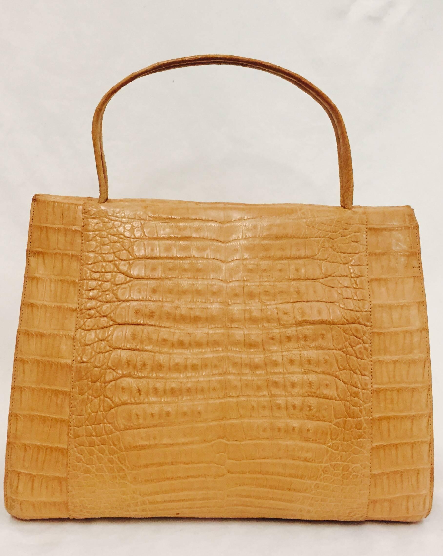 Nancy Gonzalez  Large Wallis tan Caiman Crocodile tote bag opens at top and has two rolled top handles.  One large zip compartment on one side is complemented with smaller zippered slit pocket and other multiple smaller pockets.  Magnetic closure. 