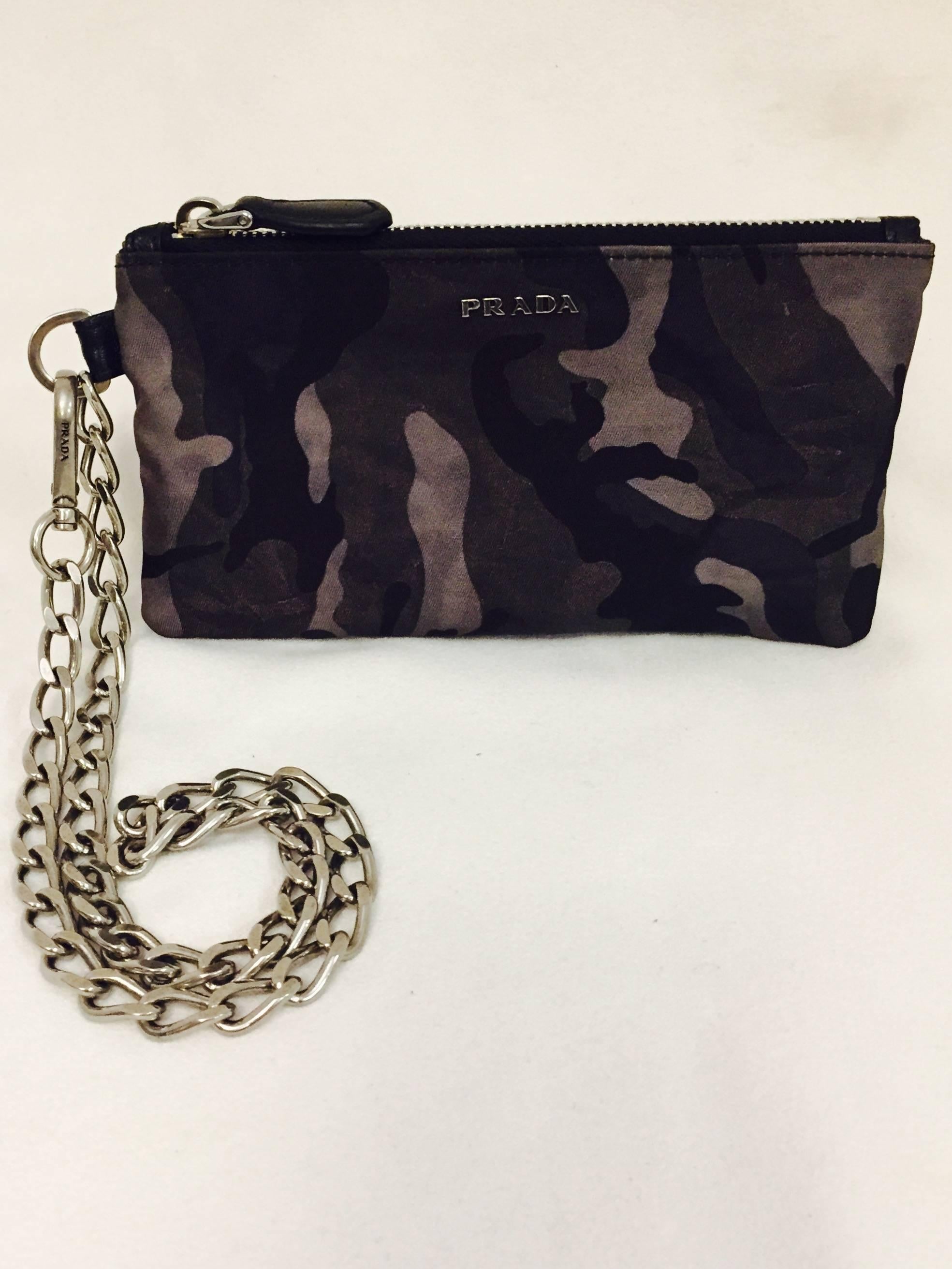 Prada's unisex, multi purpose nylon mini bag can be utilized as a wristlet, cosmetic bag or wallet that hangs from one's belt.  The small bag has a Prada logo chain that can be detached.  This is a great accessory with multi function capability