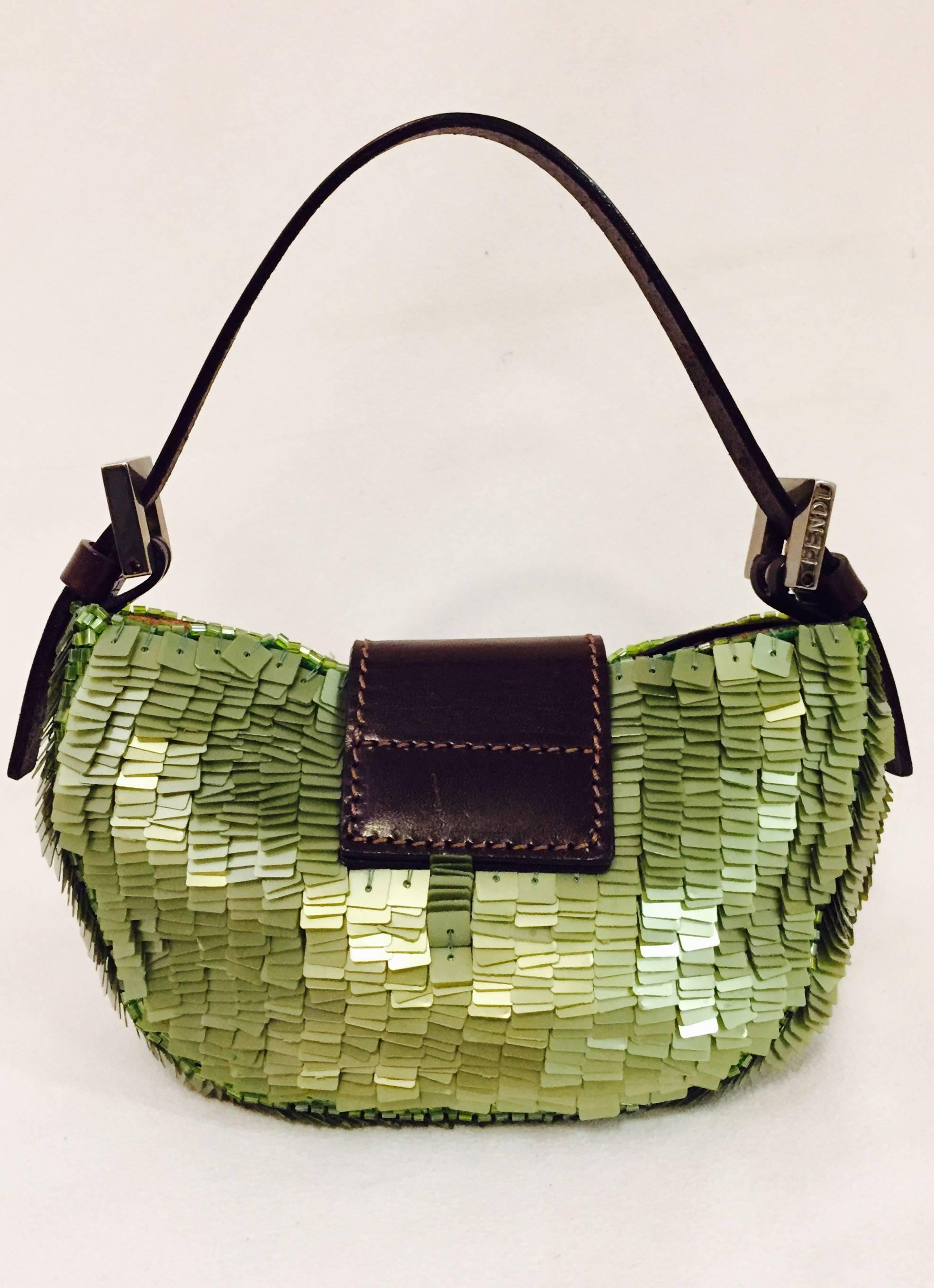 Bright green sequined/paillete croissant mini bag is finely crafted in the Fendi tradition featuring its unmistakable namesake shape that's good enough to eat!  Brown leather top handle, strap and iconic logo.  Silver tone hardware and magnetic snap