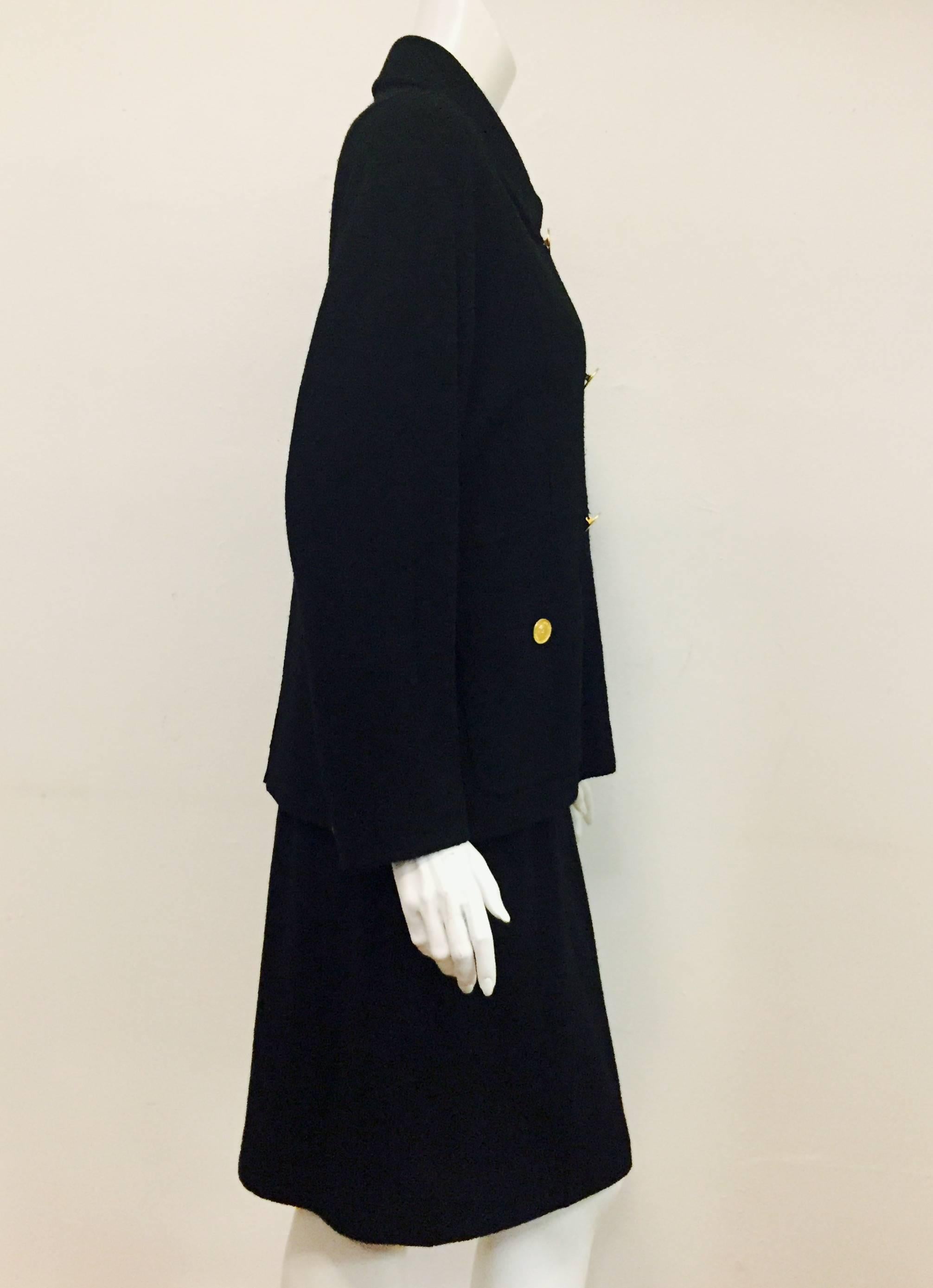 Vintage Chanel double breasted black wool suit with pointed collar and dolman sleeves.  Chanel tailleur set is highly detailed and crafted with two front slit pockets with gold buttons, as well as at the cuff of the dolman sleeves.   6-button double