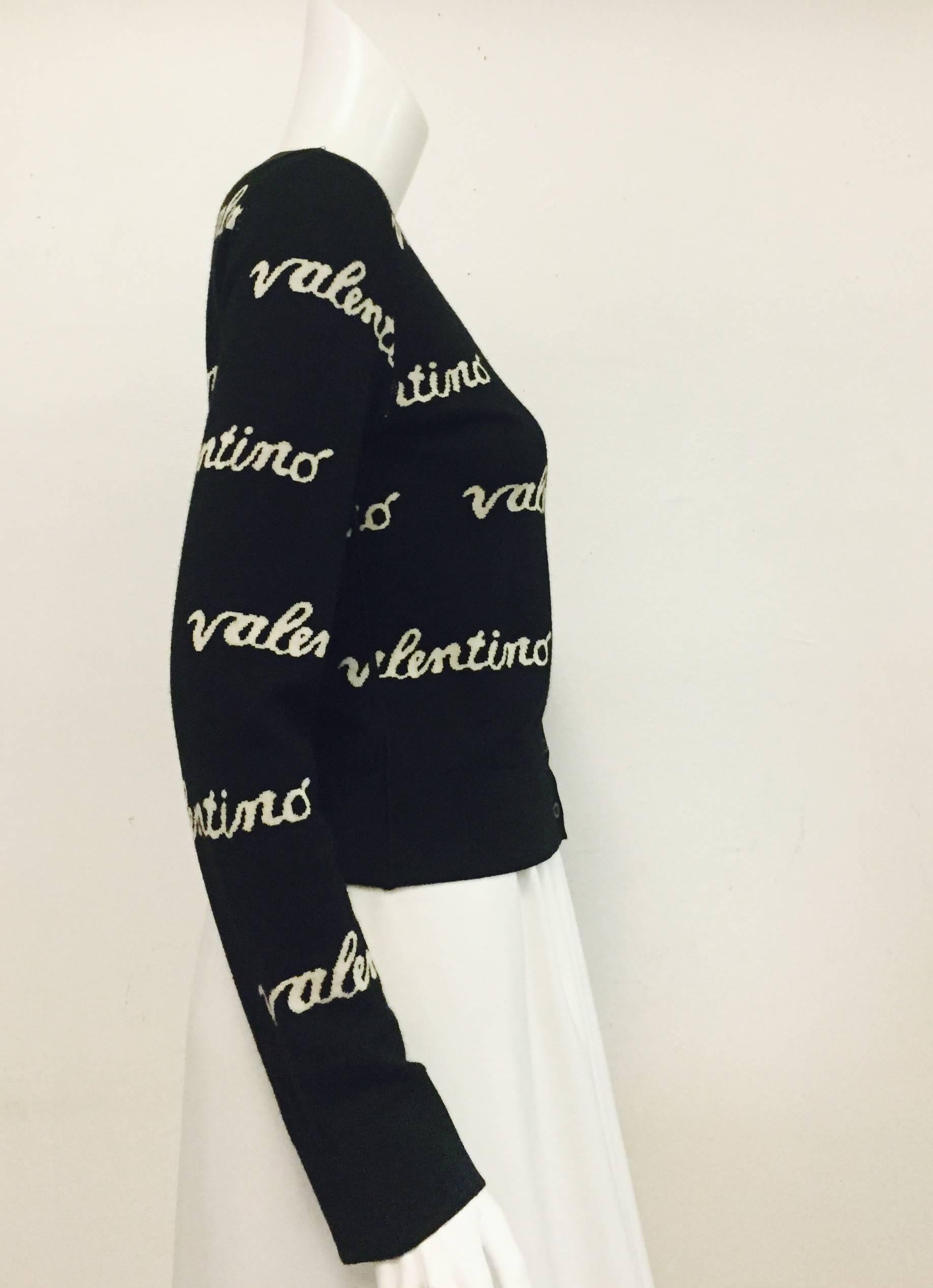 Valentino black and white trendy knit cardigan with Valentino name throughout is a great conversation piece!   This cardigan has a lining made from same knit fabric with the Valentino name in reverse - very unique!  For closure this cardigan has 7