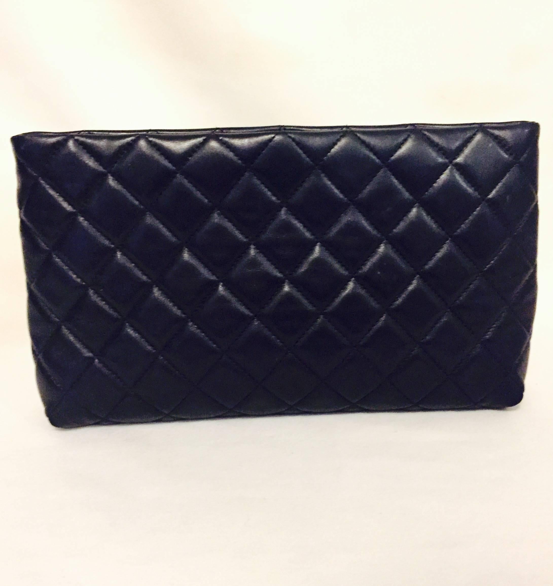A timeless classic Chanel black quilted lambskin clutch with signature double CC lock in silver tone on top for closure.   This small clutch has only one middle compartment with no pockets and is lined in suede leather.  Excellent pre-loved