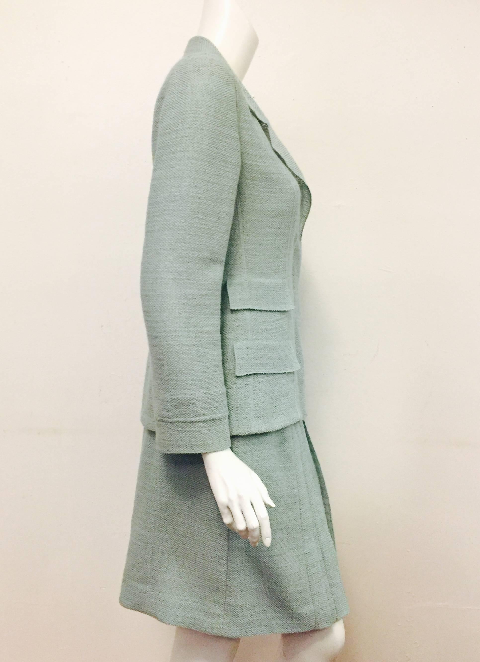 Chanel's teal wool blend lightweight tweed skirt suit with 4 flap pockets, notched collar and 3 hidden CC buttons goes from season to season.   Skirt has faux pleated details at front and hidden zipper at back.   Both the jacket and skirt are lined