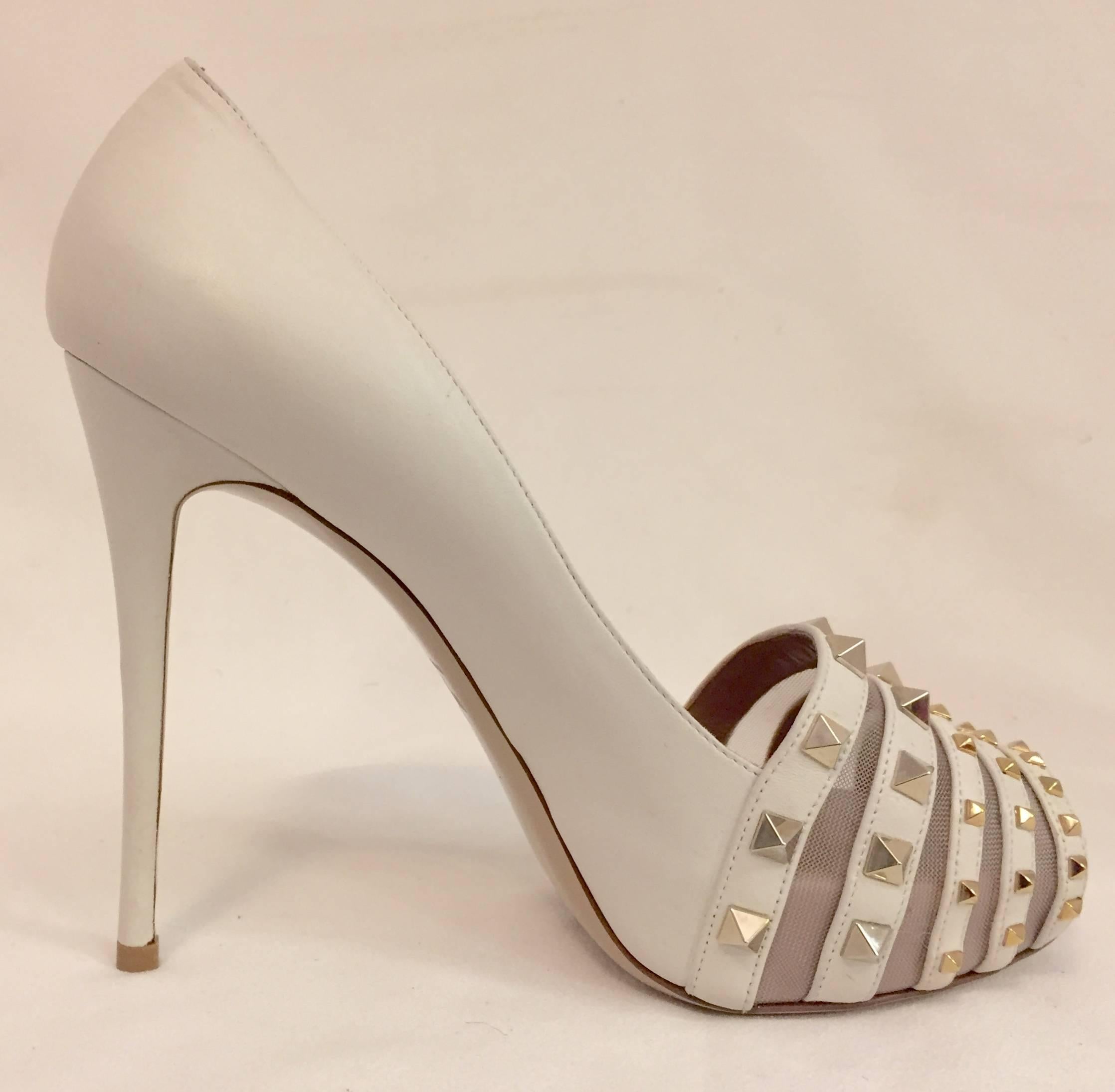 Rockstuds have become a signature Valentino Garavani flourish!  Highly prized ivory peep toe platform pumps are amplified with 5 leather bands alternating with ivory mesh between each band on the vamps.  The "kicker"?   Rockstuds adorn