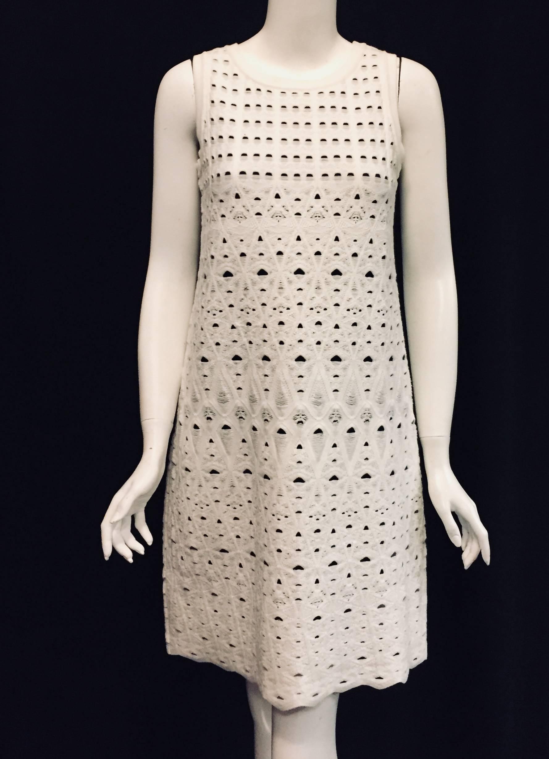 Chanel white with navy blue lining sleeveless knit dress is from the Spring 2009 collection.  This  A-line dress has a scoop neckline trimmed with ribbed knit. 
 Featuring Pointelle lace, dress is lined with navy blue viscose that is also ribbed at