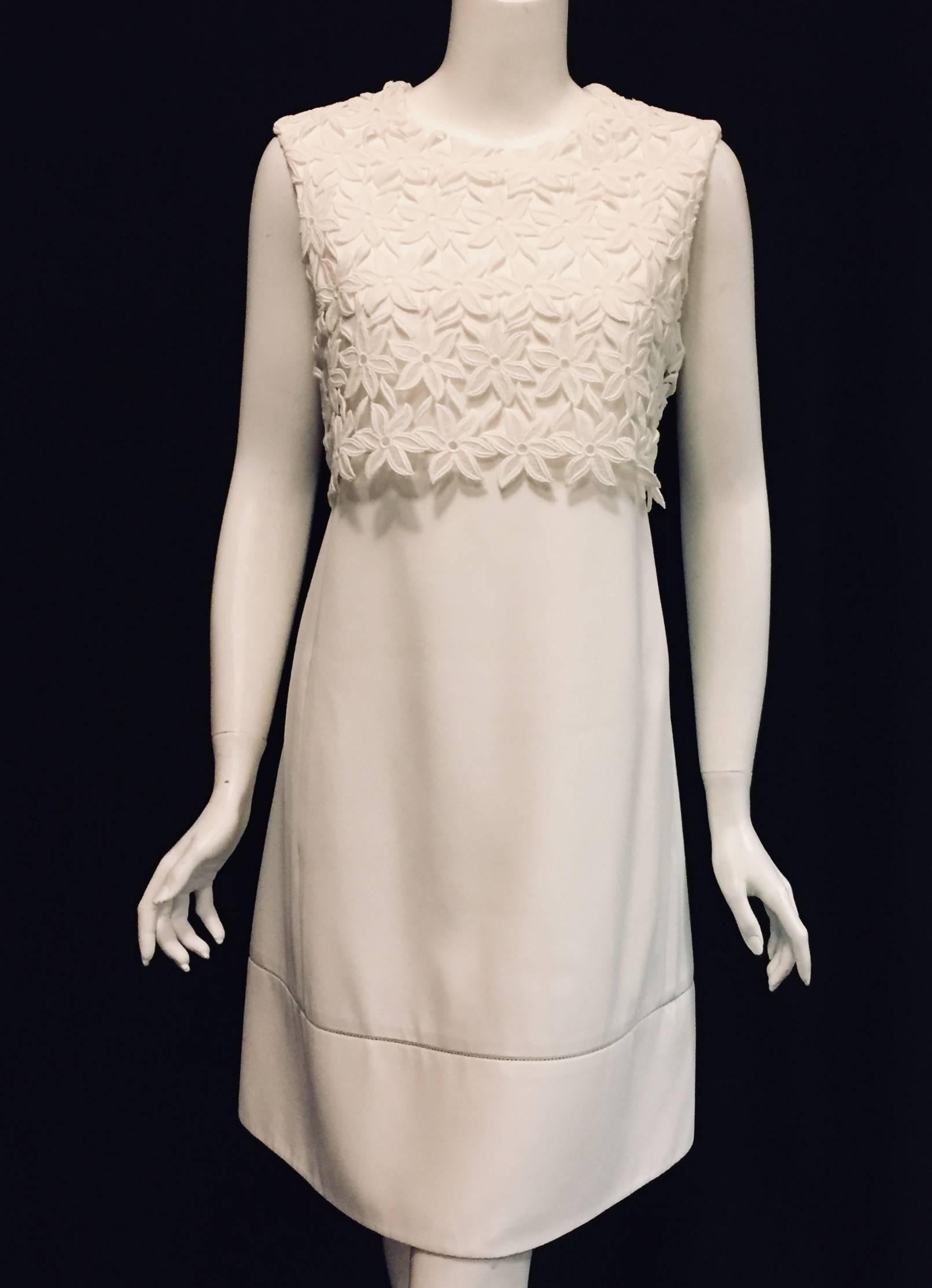 Chloe floral lace sleeveless white cotton dress is scallop cut to the waist.  A classical french romantic style dress with round neckline and a-line skirting.  The hem band is separated from the rest of the dress with thin eyelet embroidery. 