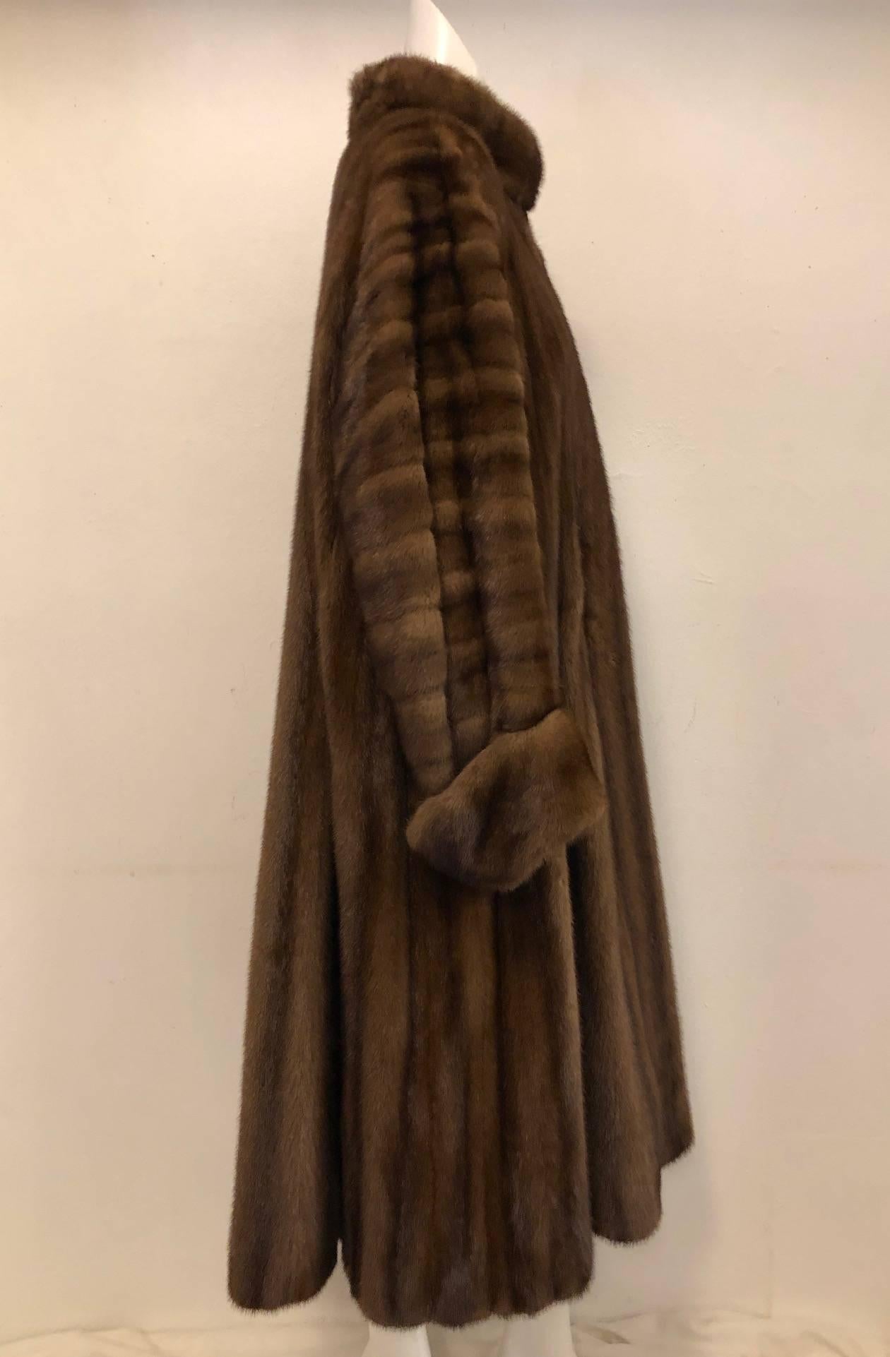 Befitting the King of Fashion's legendary status, this magnificent brown ranch mink swing coat is one for the archives!  This Yves Saint Laurent Fourrure features ultra-luxurious pelts, standup collar, two on seam pockets, and 4" deep cuffs.  