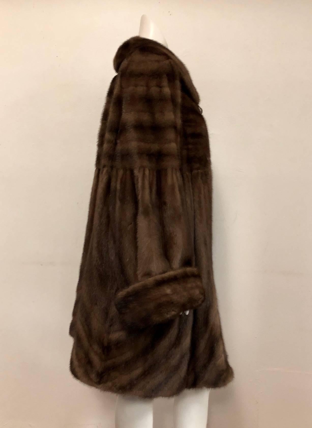 "More is More" when wearing this Magnificent Brown Mink Swing Coat!  Features ultra-luxurious pelts, shawl collar, and multi-directional construction.  Gathered body and curved cuts afford dramatic, feminine sweep.  Two on seam pockets,