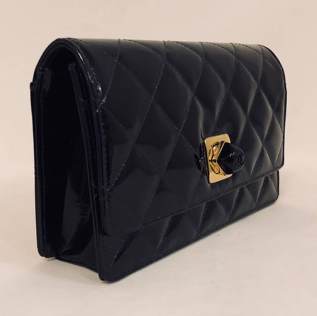 Classic Chanel Clutch is actually large enough for today's larger smartphones!  Crafted in the late 1990s, this series 5 bag features black patent diamond quilted leather, rear open slit pocket and smooth bottom and sides.  Resin signature logo