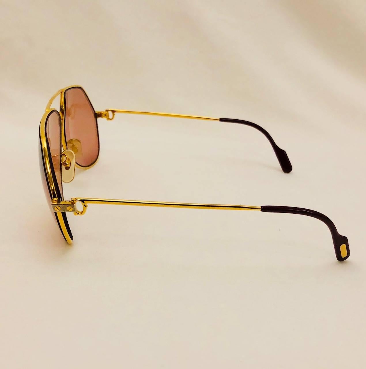 Cartier is renown for crafting some of the most desired aviator sunglasses in the world!  These Vintage Vendome Santos Satin sunglasses feature gold tone frame, signature temple tips, and two tone hardware on bridge and temples.  Unisex design. 
