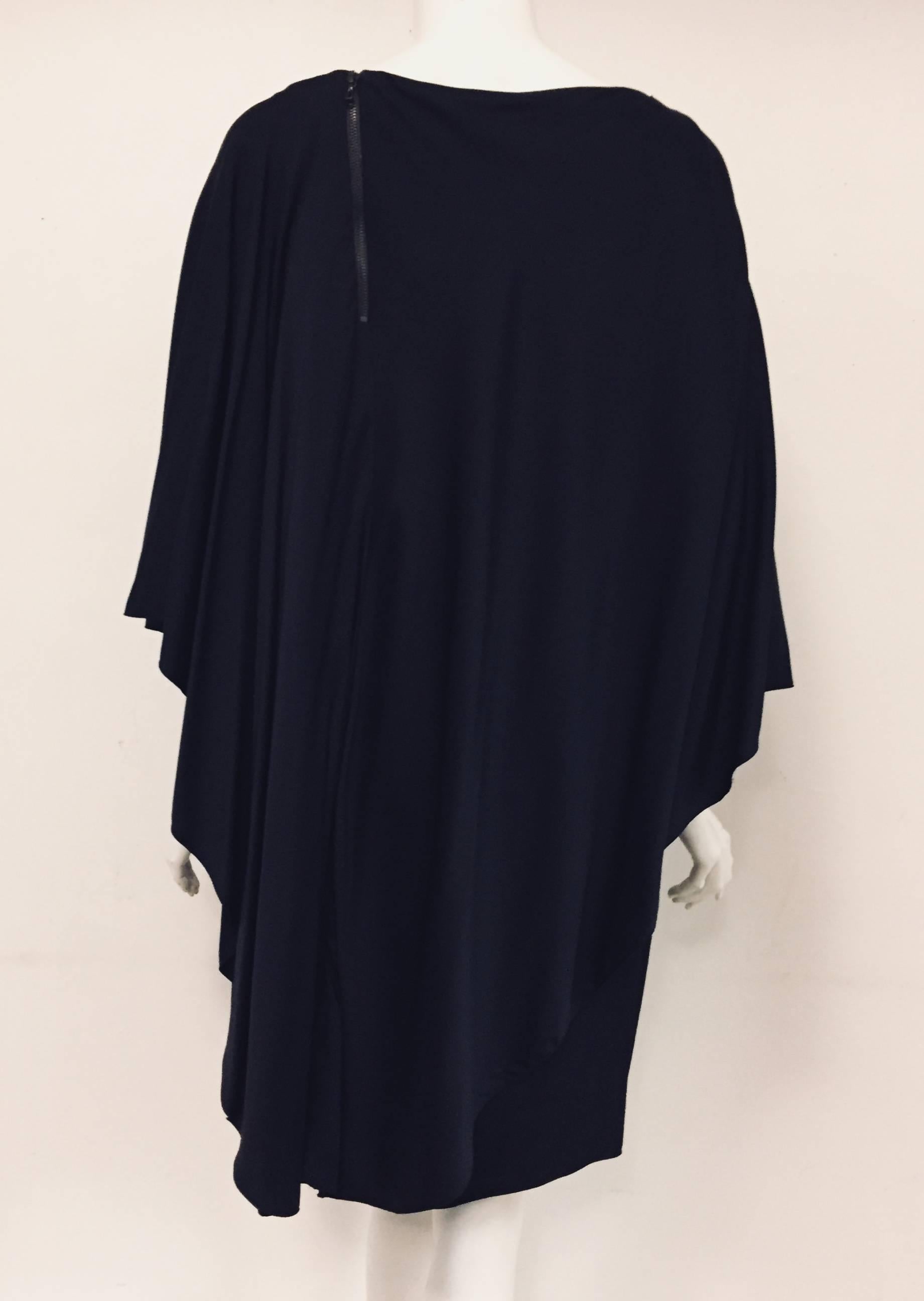 Lanvin navy blue cape dress is a study in couture techniques!  Dramatic, asymmetric, attached cape reveals sleeveless, knee-length dress.  Bateau neckline and exposed zip closure at shoulder are the finishing touches.  

Made in France