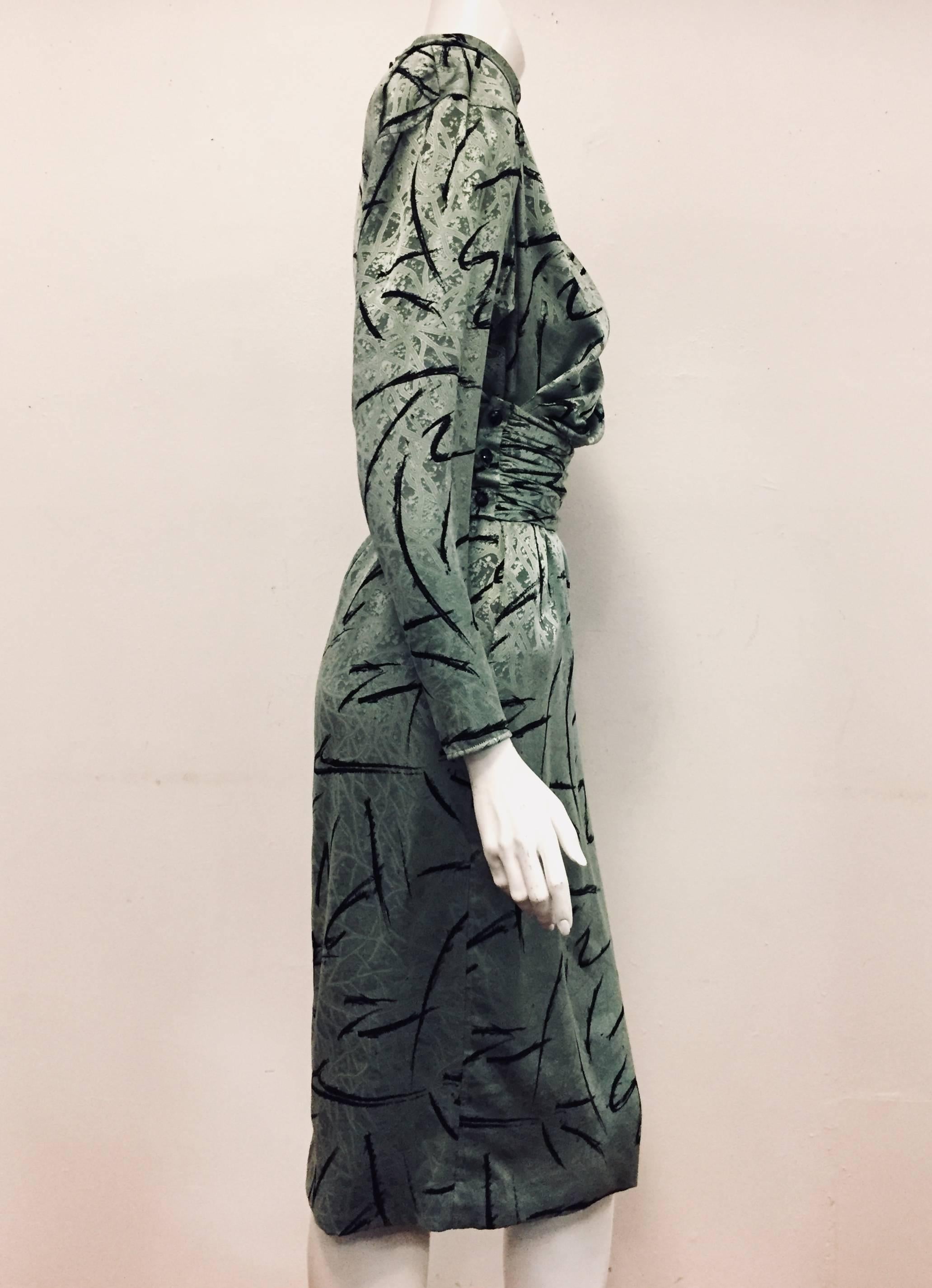 Emanuel Ungaro abstract print green jacquard long sleeve dress with same fabric gathered belt is traditional and elegant.  The turtle neck gathered collar has 3 buttons for closure at neckline with same 7 additional buttons used for back closure.  