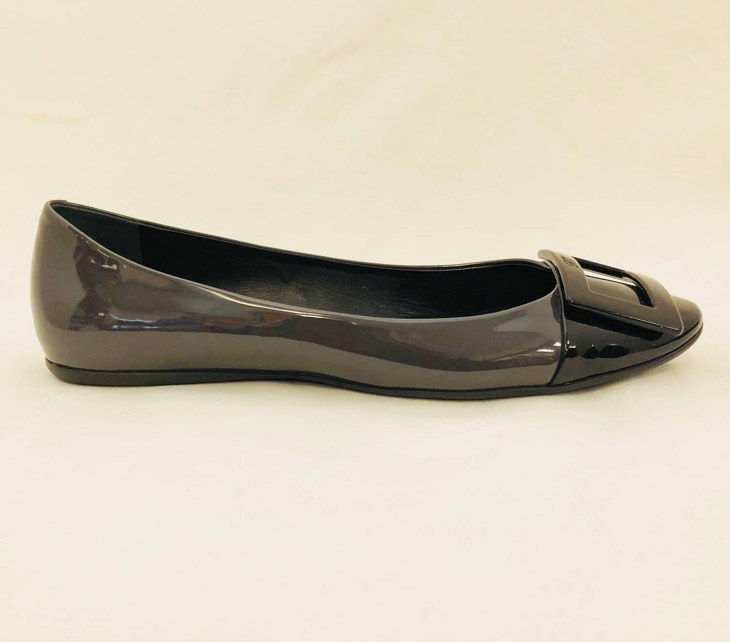 Known for creating what would become known as the Stiletto, Roger Vivier's designs are still highly desired by fashionable women around the world.  These patent leather metropolitan grey and black Belle de Nuit pumps with round cap toe are lined in