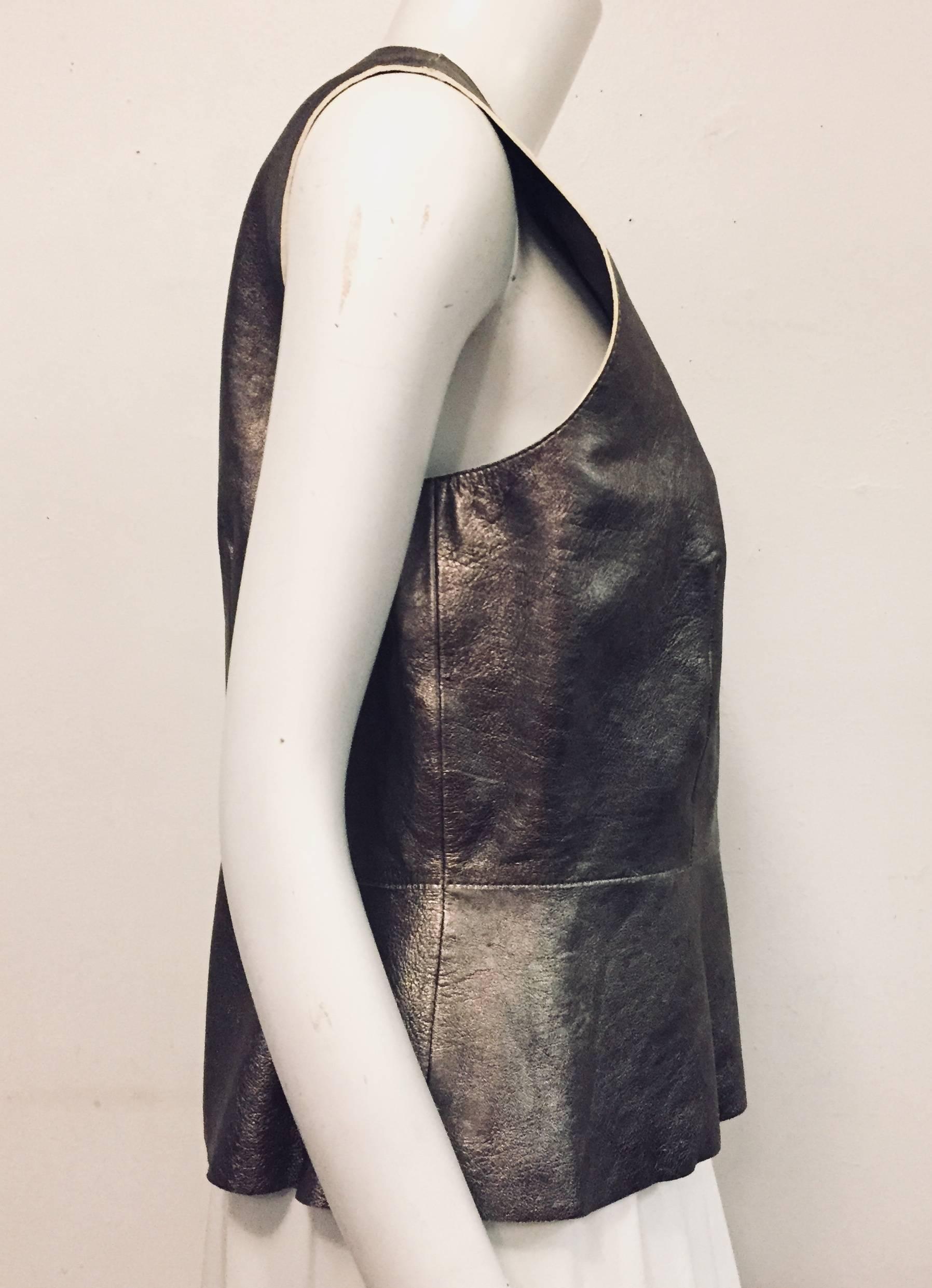 Daring Gerard Darel metallic pewter sheepskin sleeveless top highlights French design and execution.  Features ultra-luxurious leather, peek a boo opening at the back and round neckline.  Fully lined.  Fitted and flared waistline celebrates a