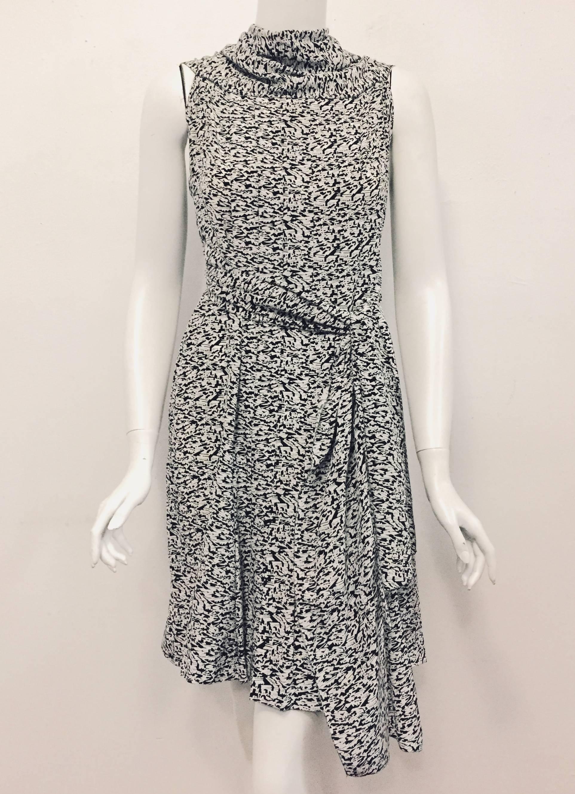 This Chanel innovate city skyline print dress in black and white silk with attached scarf that can be worn in various ways is a great travel piece. The city skyline silk fabric will not wrinkle and it also has the CHANEL name written allover the