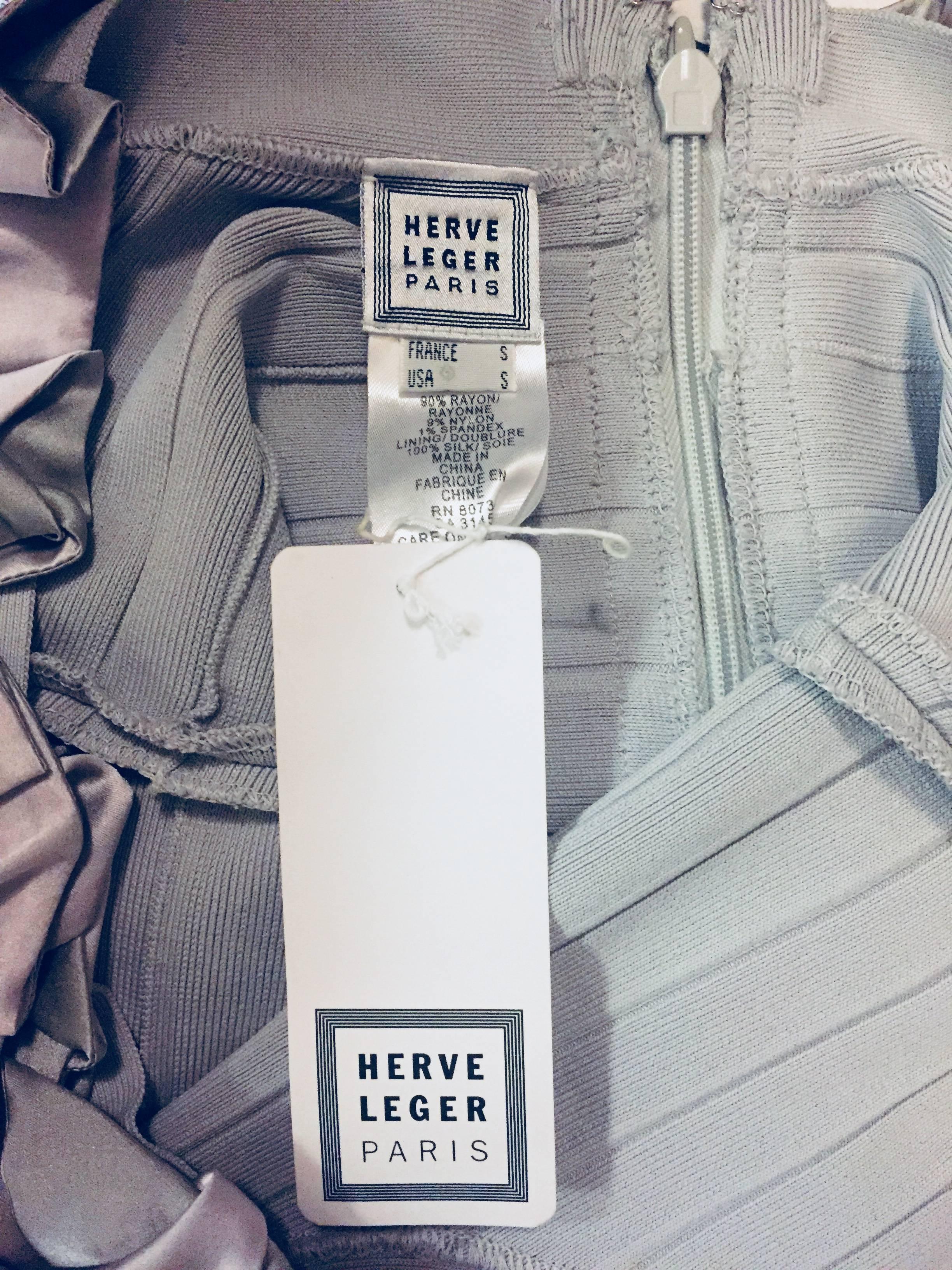 Herve Leger tapered bandage grey knit dress designed for that hour glass figure.  The scoop neckline is adorned with grey and lavender silk ties that are intertwined around the neckline front and back with 2 ties falling loosely at the front.  For