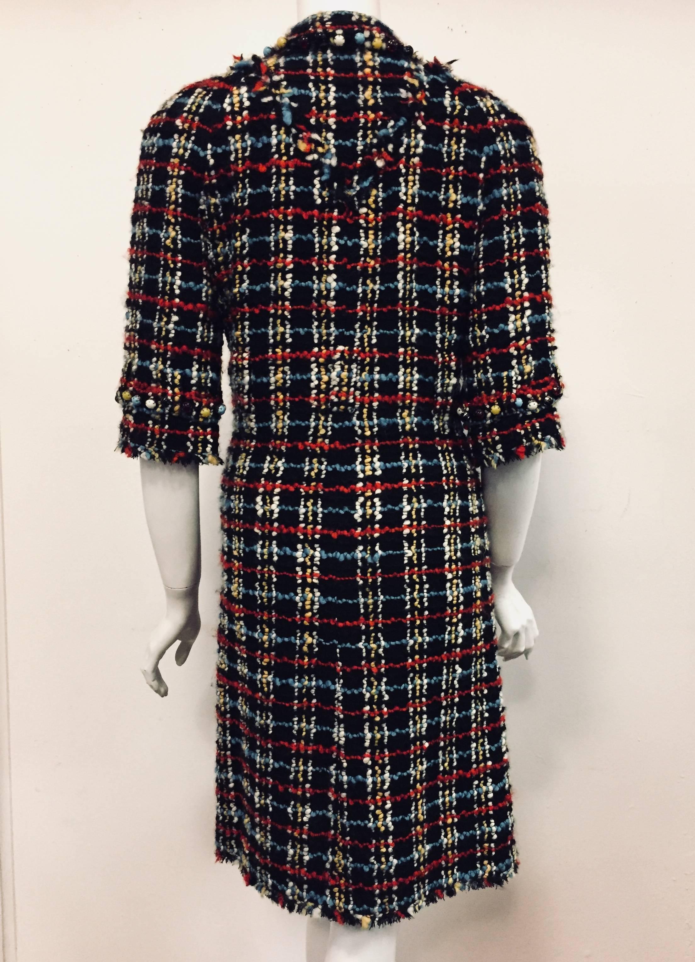 Chanel black base and multicolor wool bouclé dress coat will make you stand out in a crowd.  This fringed at sleeves and hem dress features faux semi precious stones in red, black, yellow and turquoise on collar, cuffs, pockets and both sides of