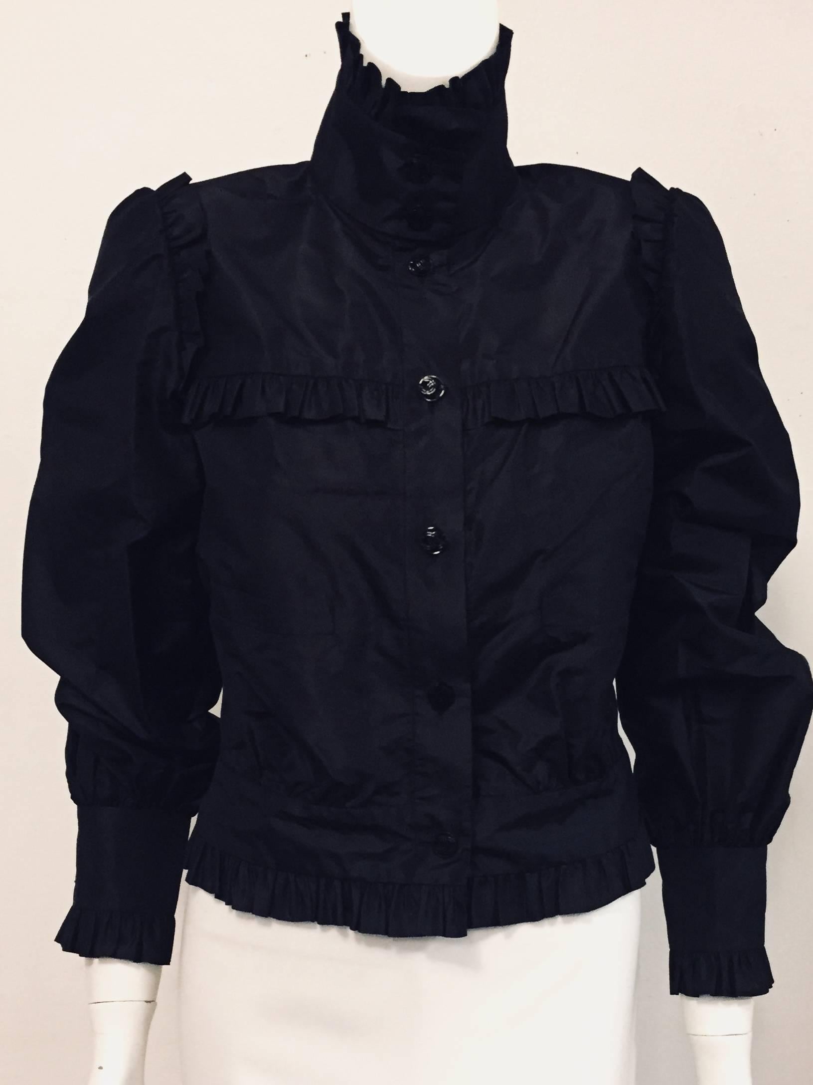 Chanel detailed multi ruffled black silk taffeta with Mandarin collar and 2 Chanel CC logo black buttons for closure.  To continue the front closure on this lightweight jacket, 5 supplementary Chanel CC buttons were added from collar to waist. 