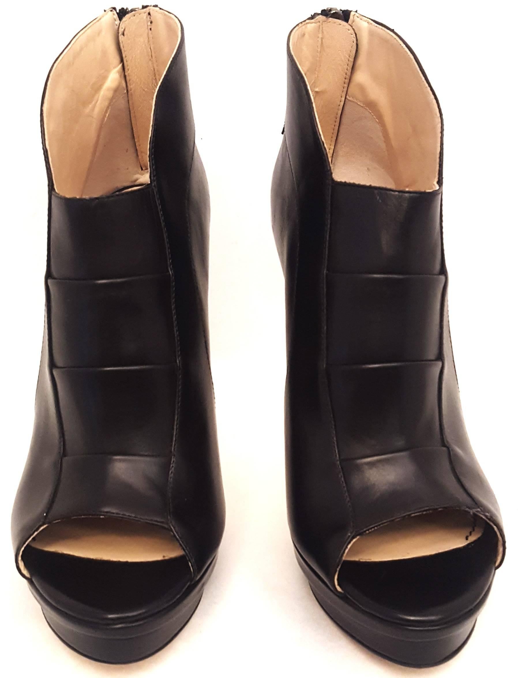 Jerome C. Rousseau Riviera black calfskin ankle boot features a back zipper and peep toe.  The vamp has detailed calfskin straps across it for added texture.  These boots are fully lined in beige leather and the back zipper at heel makes it great