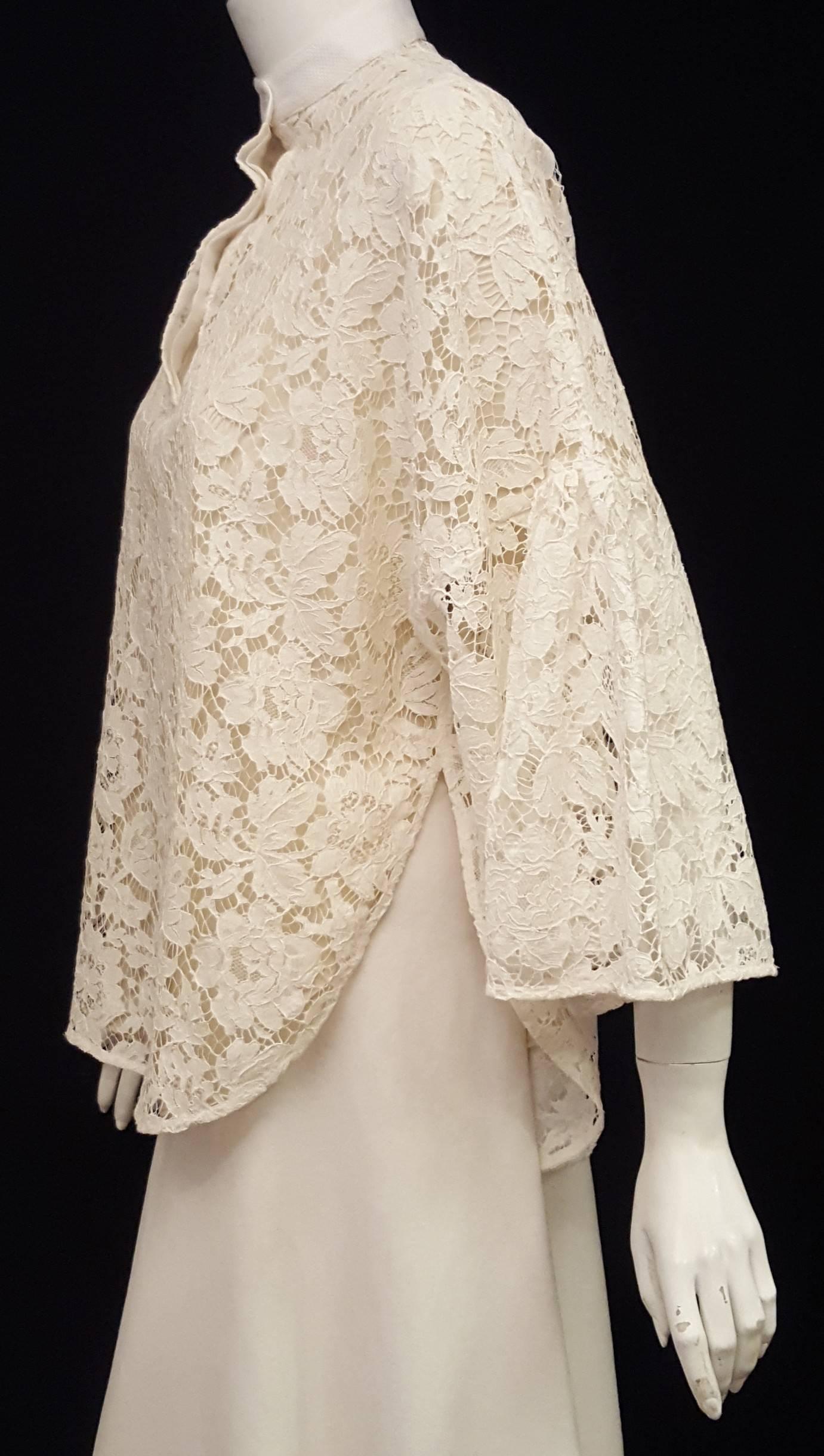 Ivory lace top with mandarin collar and and 3 button front closure is all Valentino Garavani!  Features 3/4 length bell sleeve that is gathered at the elbow, relaxed dolman silhouette, rounded hem and side slits.  This blouse can be worn with a