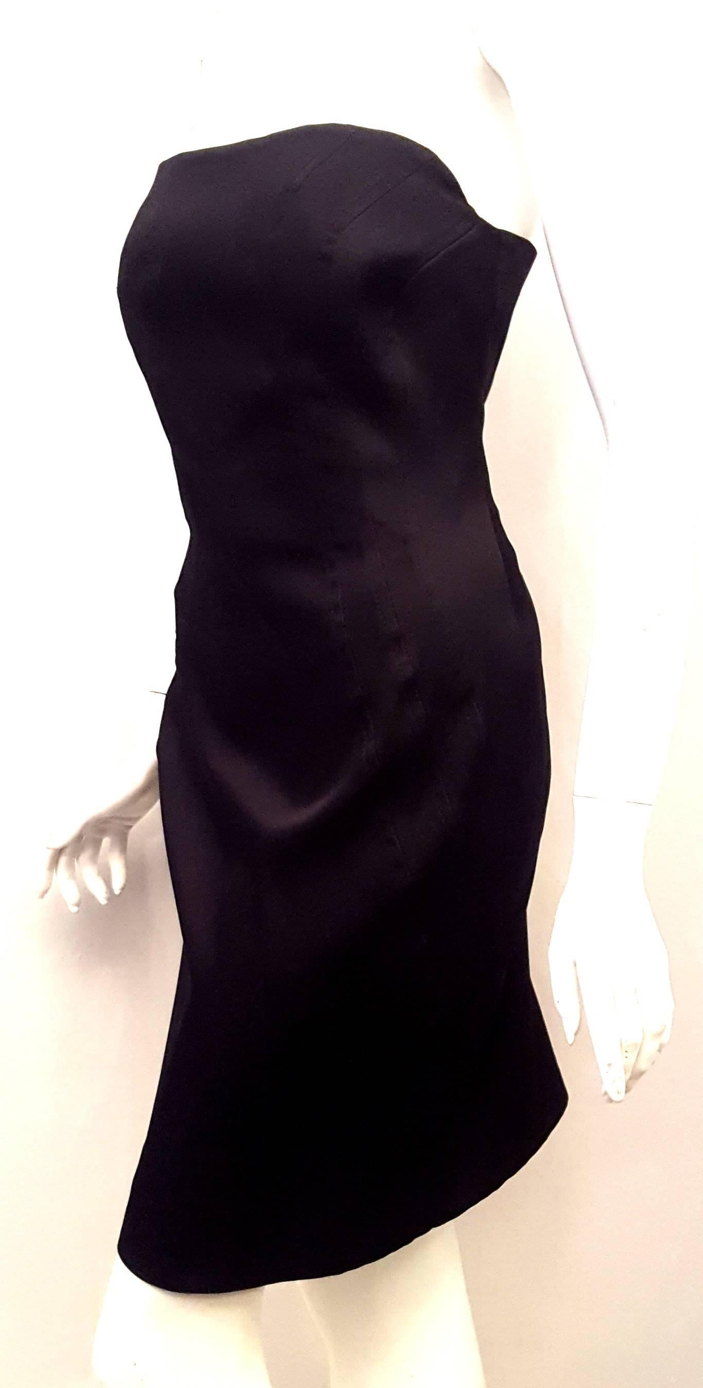 This Escada black strapless dress crafted luxuriously as stipulated by the House of Escada is a bit more than the run of the mill LBD.  This Escada dress has a bustier style bodice with an inner corset for lifting and tighting.  For closure this