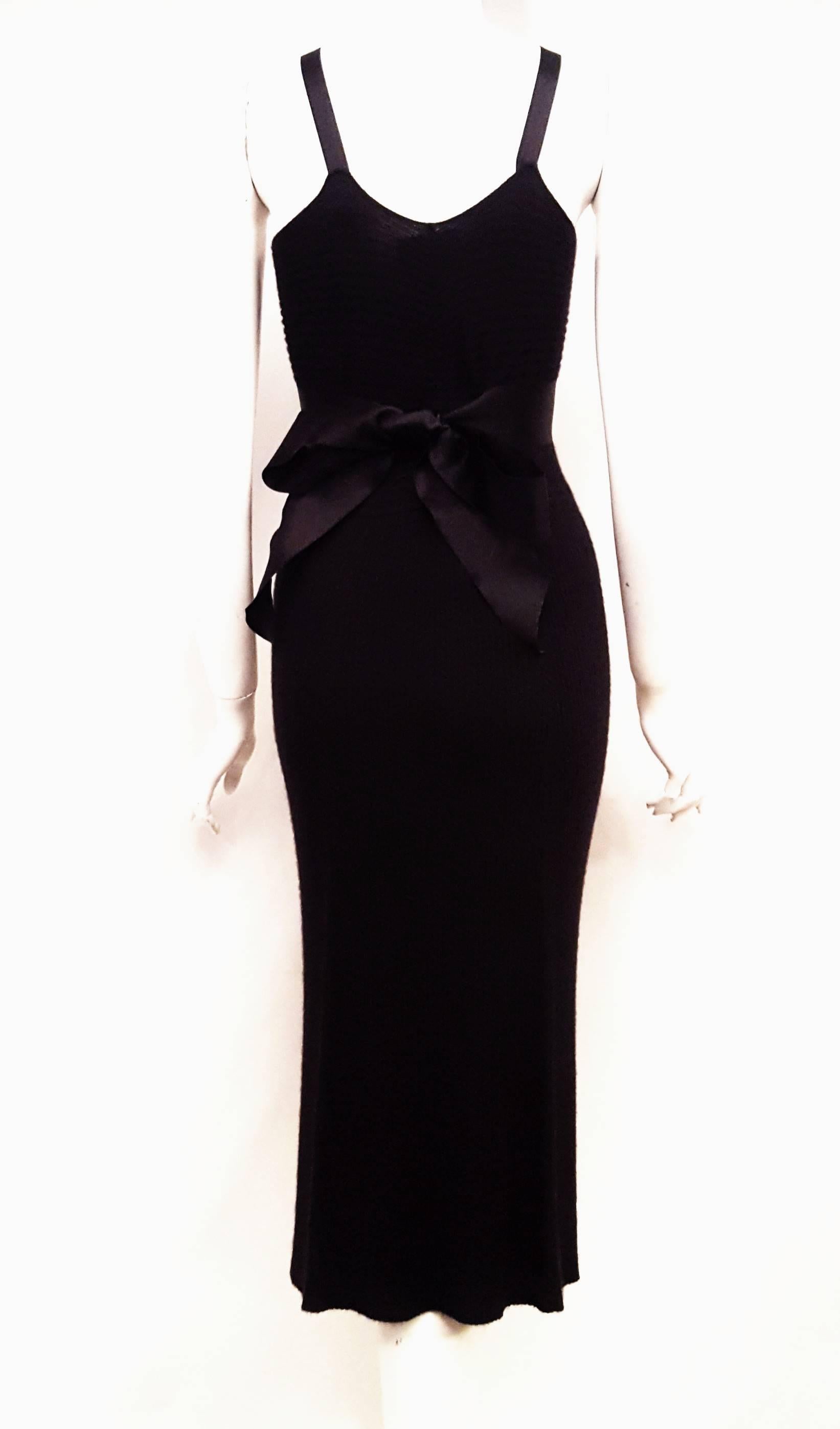 Chanel black cashmere and silk midi dress with satin ribbon spaguetti style straps shows off a satin wide ribbon from the bust line that ties to the back of the dress.  This ribbed knit dress comes down to mid calf for that casual but elegant look. 