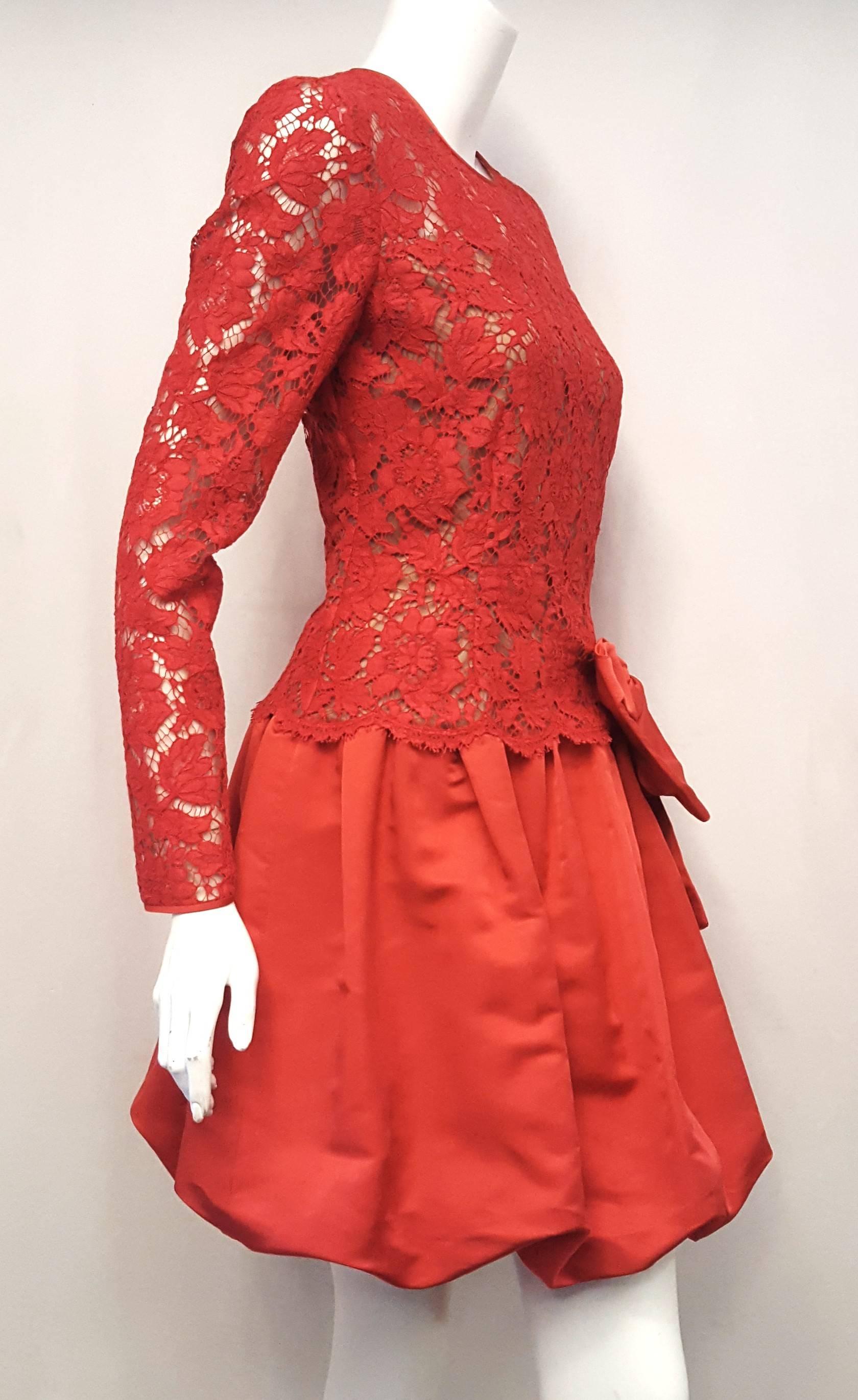 Valentino vibrant red sheer lace dress with oversized side bow at drop waist on satin bubble skirt makes a dramatic statement!.   This dress was created on the 50th anniversary of the iconic Valentino fashion house.  This red lace and silk satin