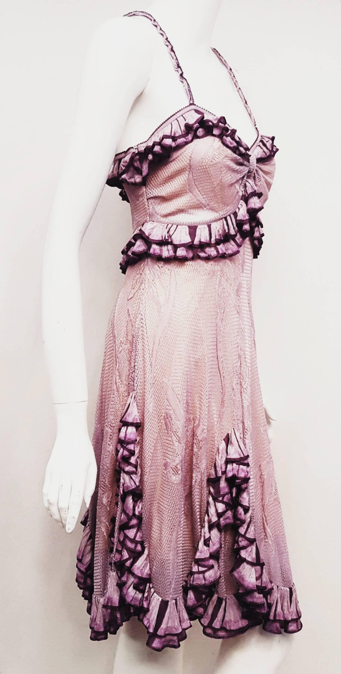 Christian Dior dress was designed by John Galliano for the 2010/2011 collection, his last for this legendary house.  This lavender knit crochet lace dress features empire waist and ruffles highlighted in purple.  Concealed zip closure at the side. 
