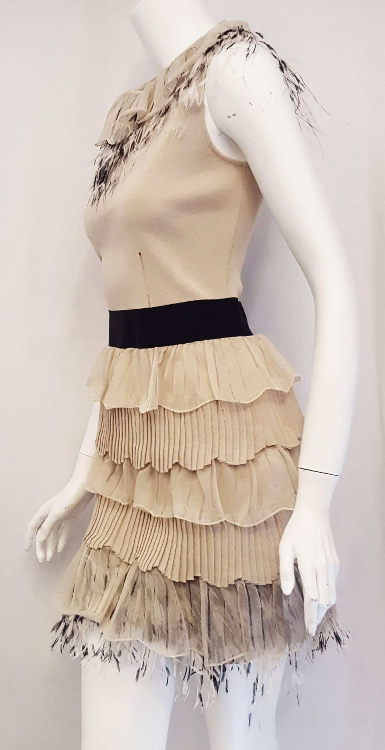 Valentino beige sleeveless knit dress with ruffle collar and Ostrich feathers decorations is accentuated waist with a black grosgrain ribbon.  For the bottom of the dress alternating ruffle layers of beige silk with pleated knit ruffles down to the